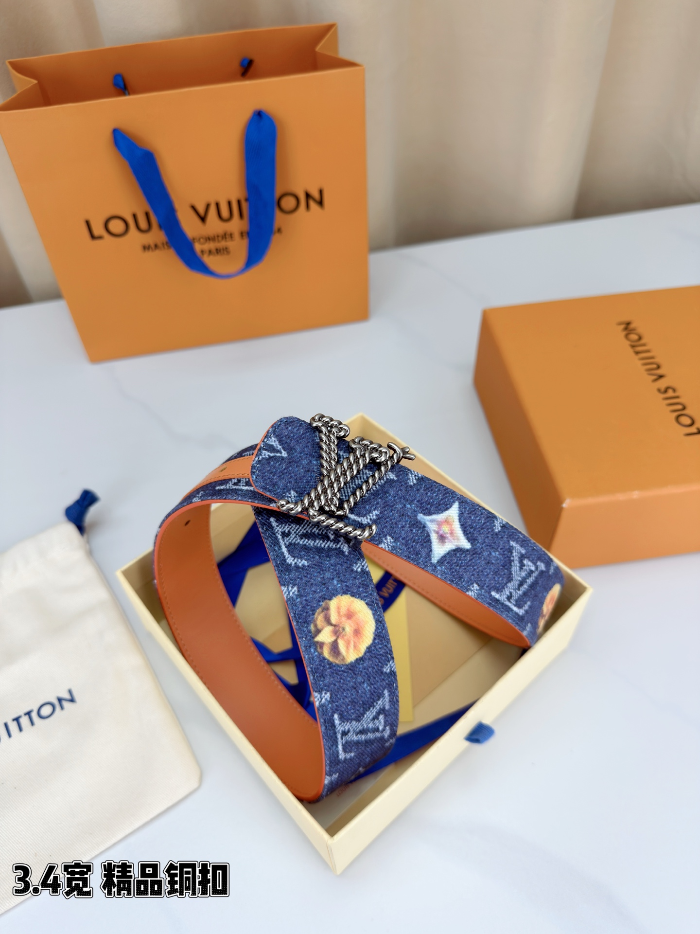 路易威登3.4宽精品铜扣腰带，深蓝牛仔邂逅暖橙皮革，双面风情随心切换。金色扭绳LV扣熠熠生辉，银链V形扣