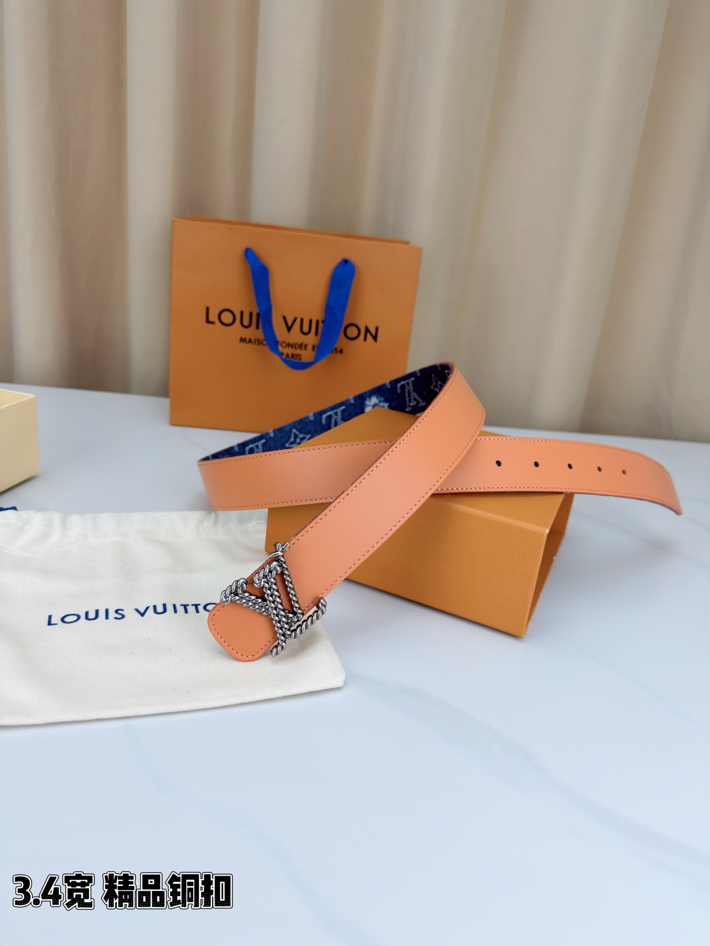 路易威登3.4宽精品铜扣腰带，深蓝牛仔邂逅暖橙皮革，双面风情随心切换。金色扭绳LV扣熠熠生辉，银链V形扣
