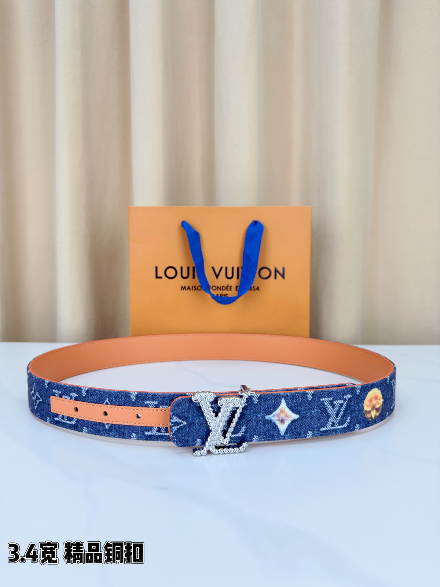 路易威登3.4宽精品铜扣腰带，深蓝牛仔邂逅暖橙皮革，双面风情随心切换。金色扭绳LV扣熠熠生辉，银链V形扣
