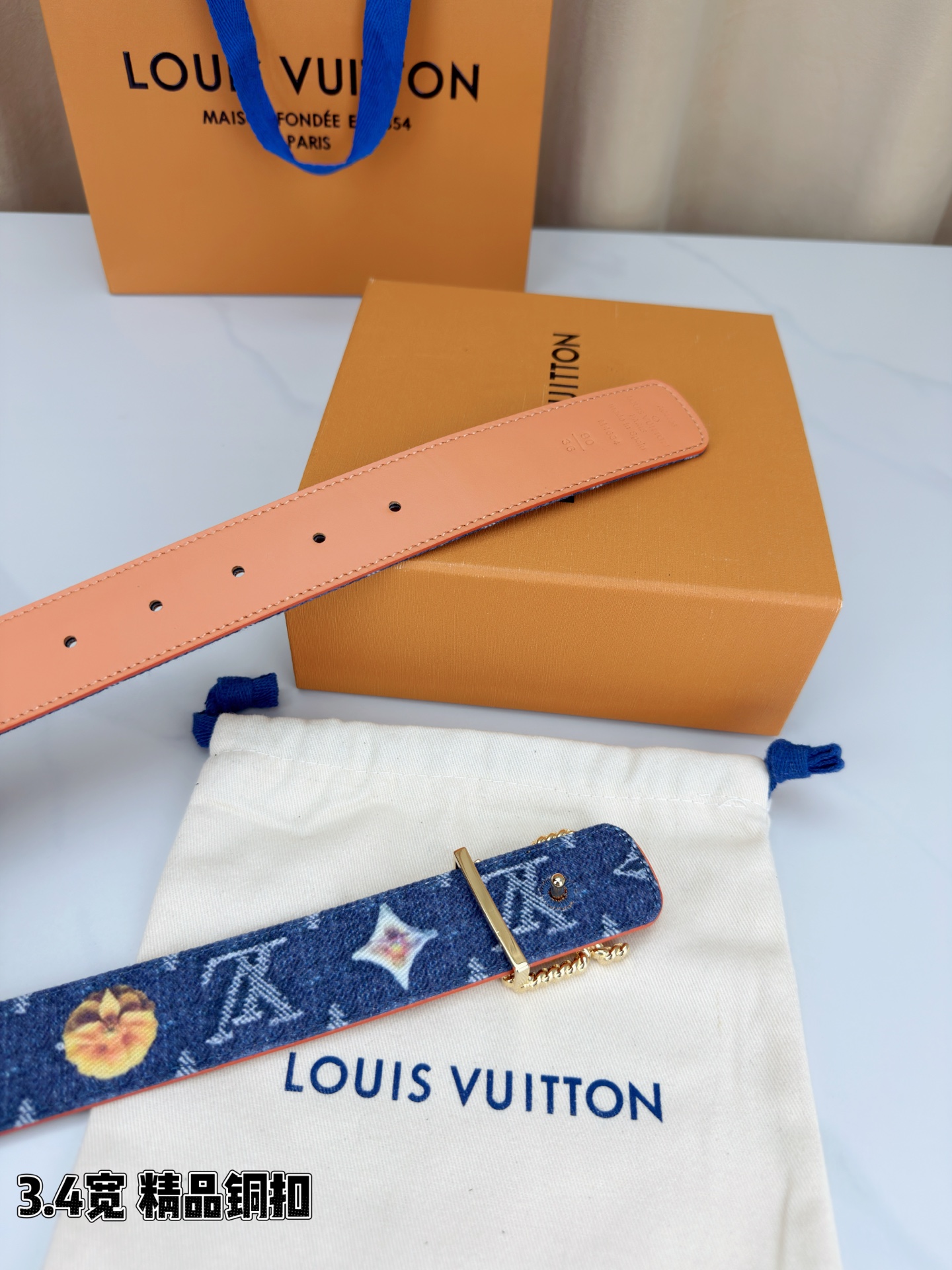 路易威登3.4宽精品铜扣腰带，深蓝牛仔邂逅暖橙皮革，双面风情随心切换。金色扭绳LV扣熠熠生辉，银链V形扣