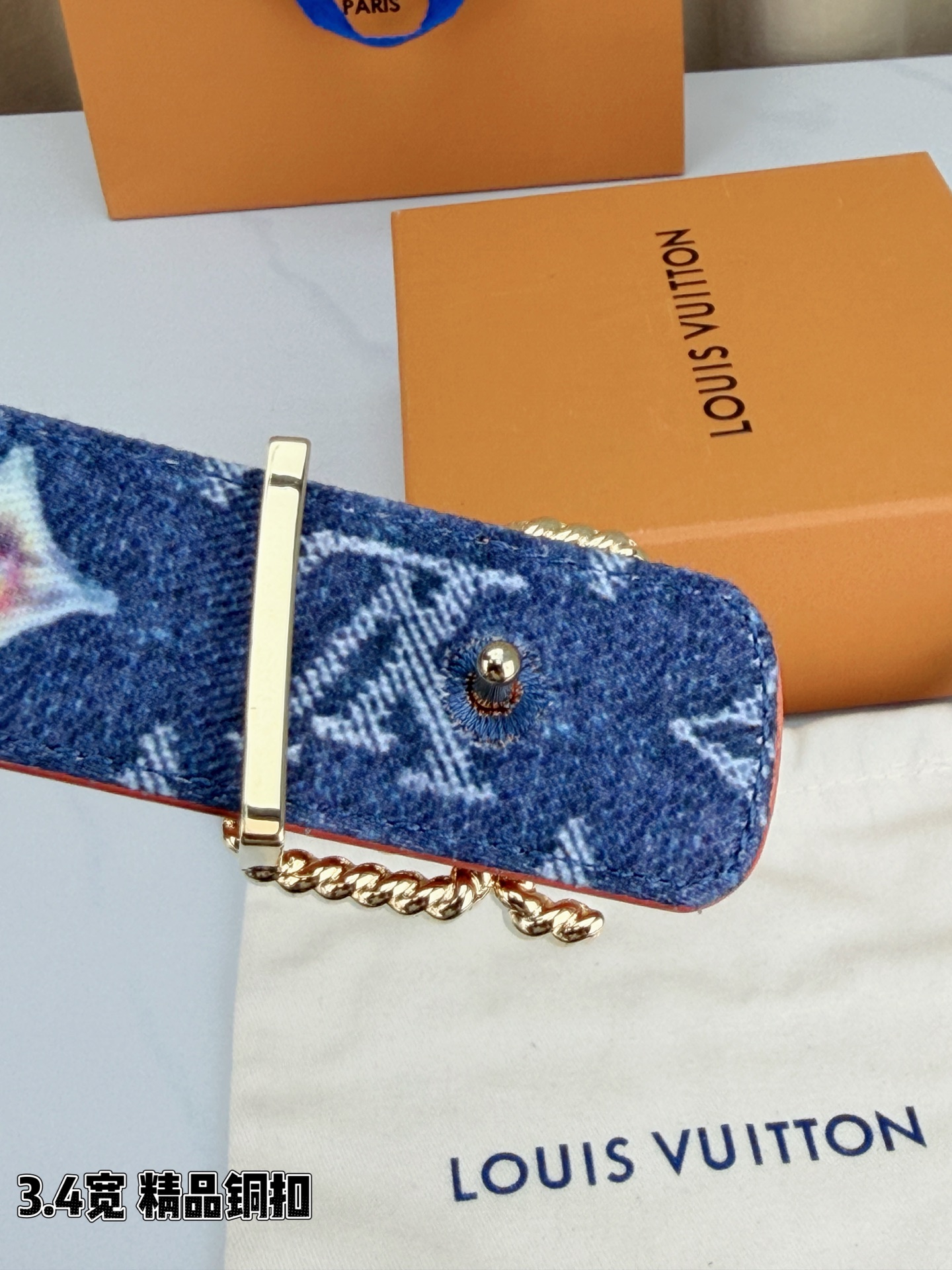 路易威登3.4宽精品铜扣腰带，深蓝牛仔邂逅暖橙皮革，双面风情随心切换。金色扭绳LV扣熠熠生辉，银链V形扣