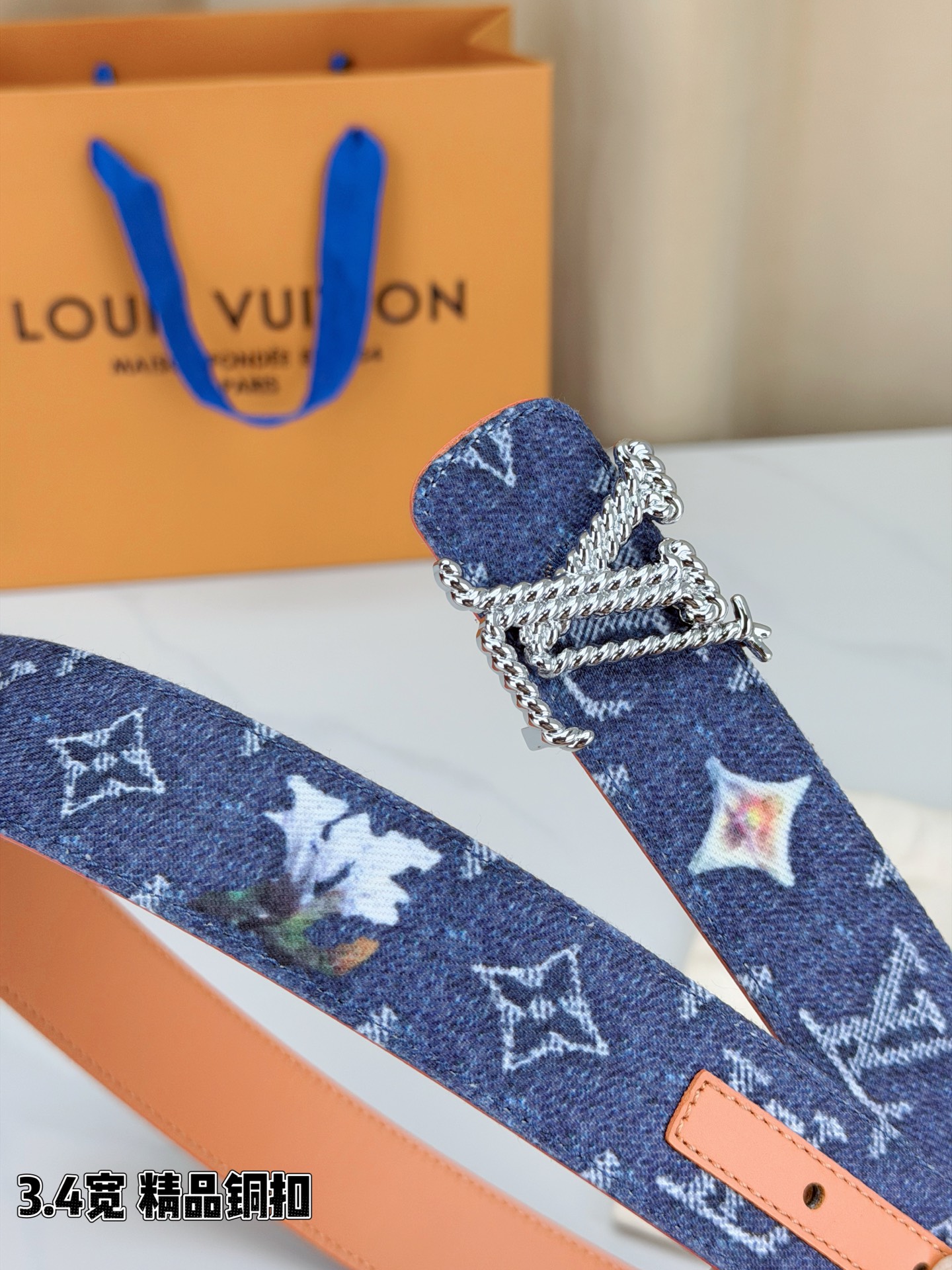 路易威登3.4宽精品铜扣腰带，深蓝牛仔邂逅暖橙皮革，双面风情随心切换。金色扭绳LV扣熠熠生辉，银链V形扣