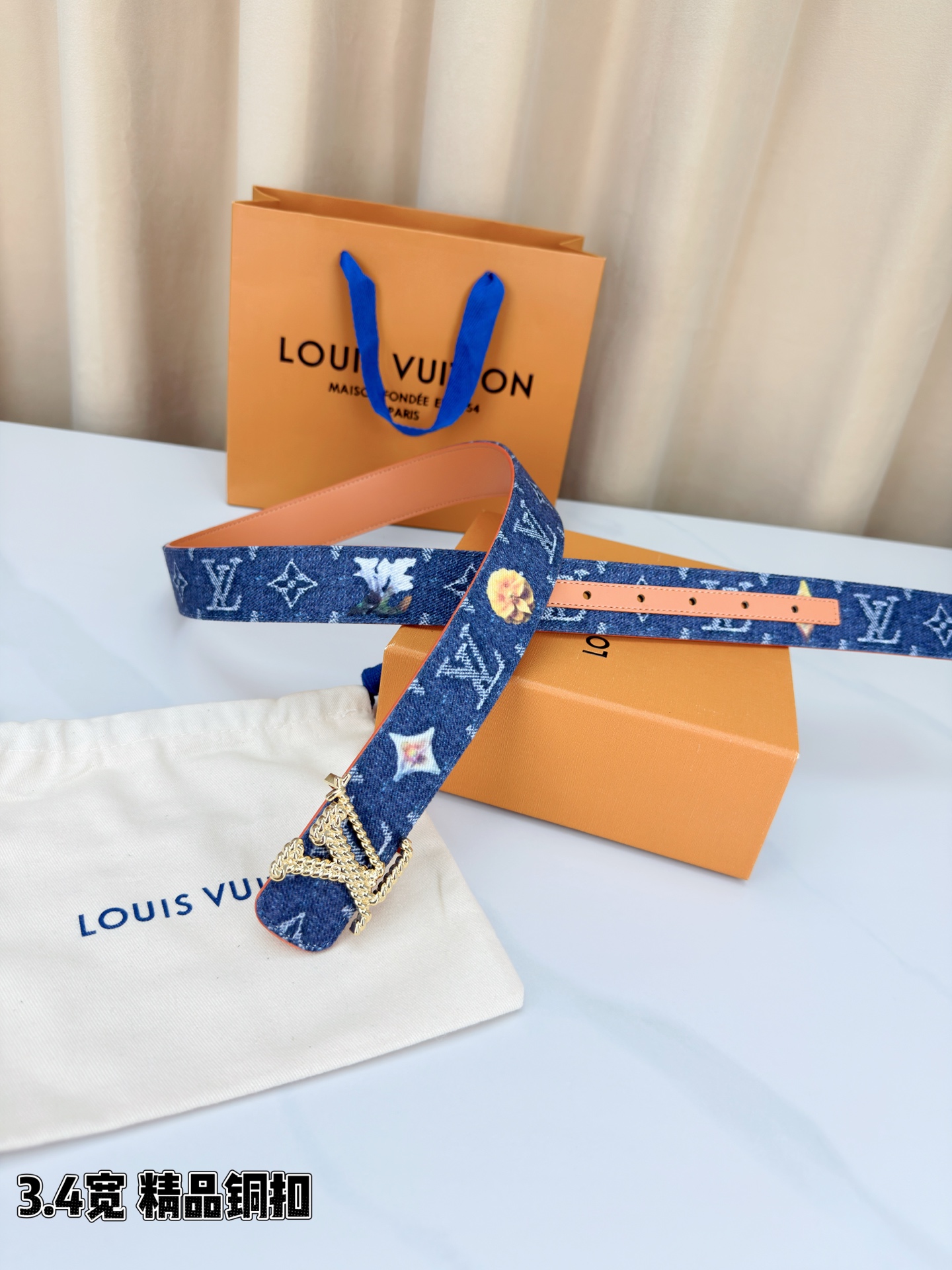 路易威登3.4宽精品铜扣腰带，深蓝牛仔邂逅暖橙皮革，双面风情随心切换。金色扭绳LV扣熠熠生辉，银链V形扣