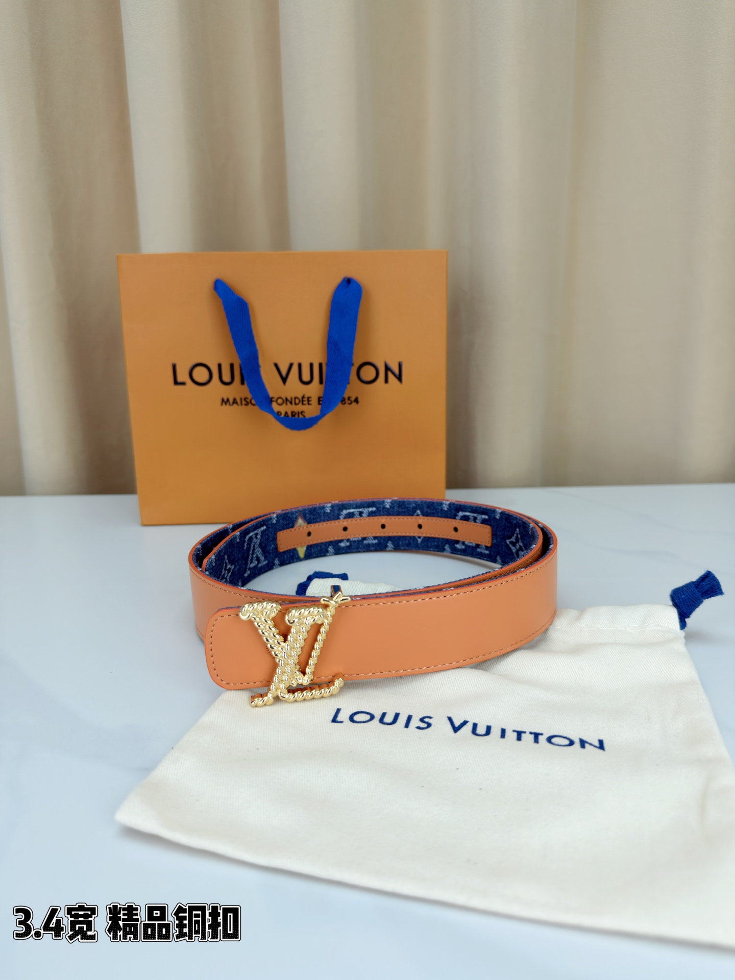 路易威登3.4宽精品铜扣腰带，深蓝牛仔邂逅暖橙皮革，双面风情随心切换。金色扭绳LV扣熠熠生辉，银链V形扣