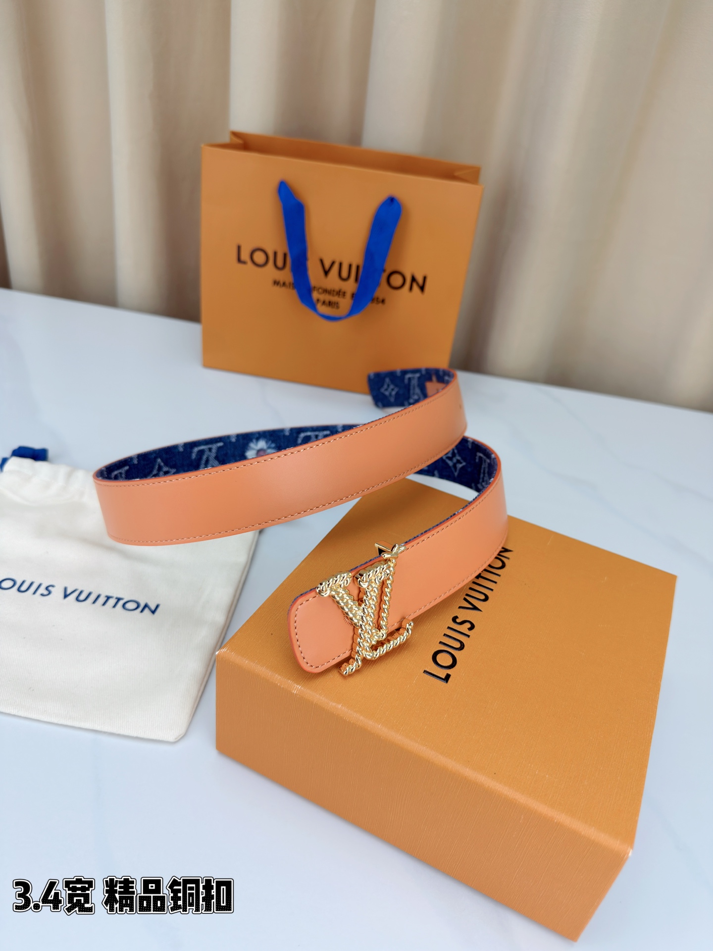 路易威登3.4宽精品铜扣腰带，深蓝牛仔邂逅暖橙皮革，双面风情随心切换。金色扭绳LV扣熠熠生辉，银链V形扣