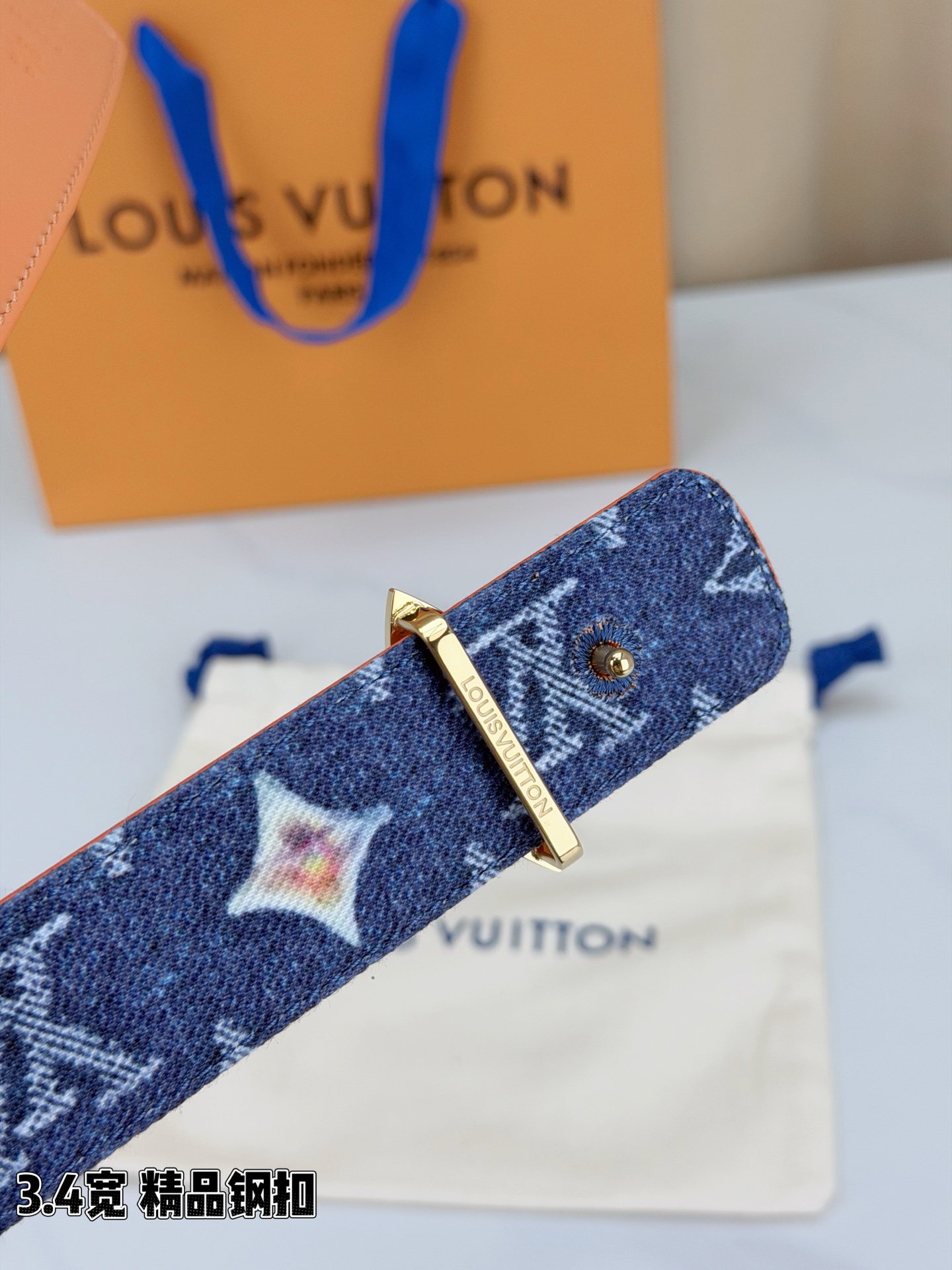 路易威登3.4宽精品钢扣腰带，深蓝牛仔邂逅经典老花，白色LV印记与浅橙花朵交相辉映。镂空四叶花扣金色华贵