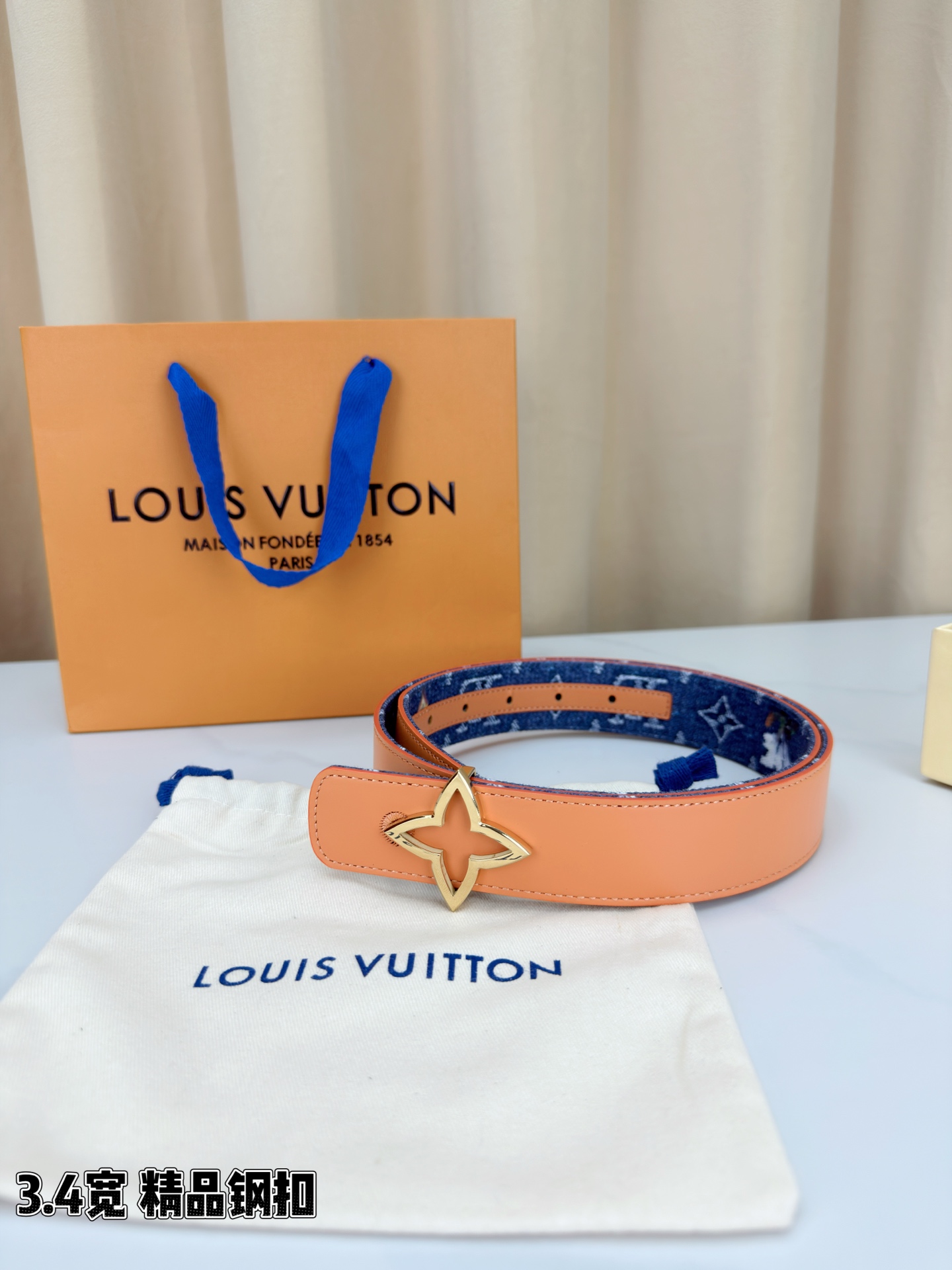 路易威登3.4宽精品钢扣腰带，深蓝牛仔邂逅经典老花，白色LV印记与浅橙花朵交相辉映。镂空四叶花扣金色华贵