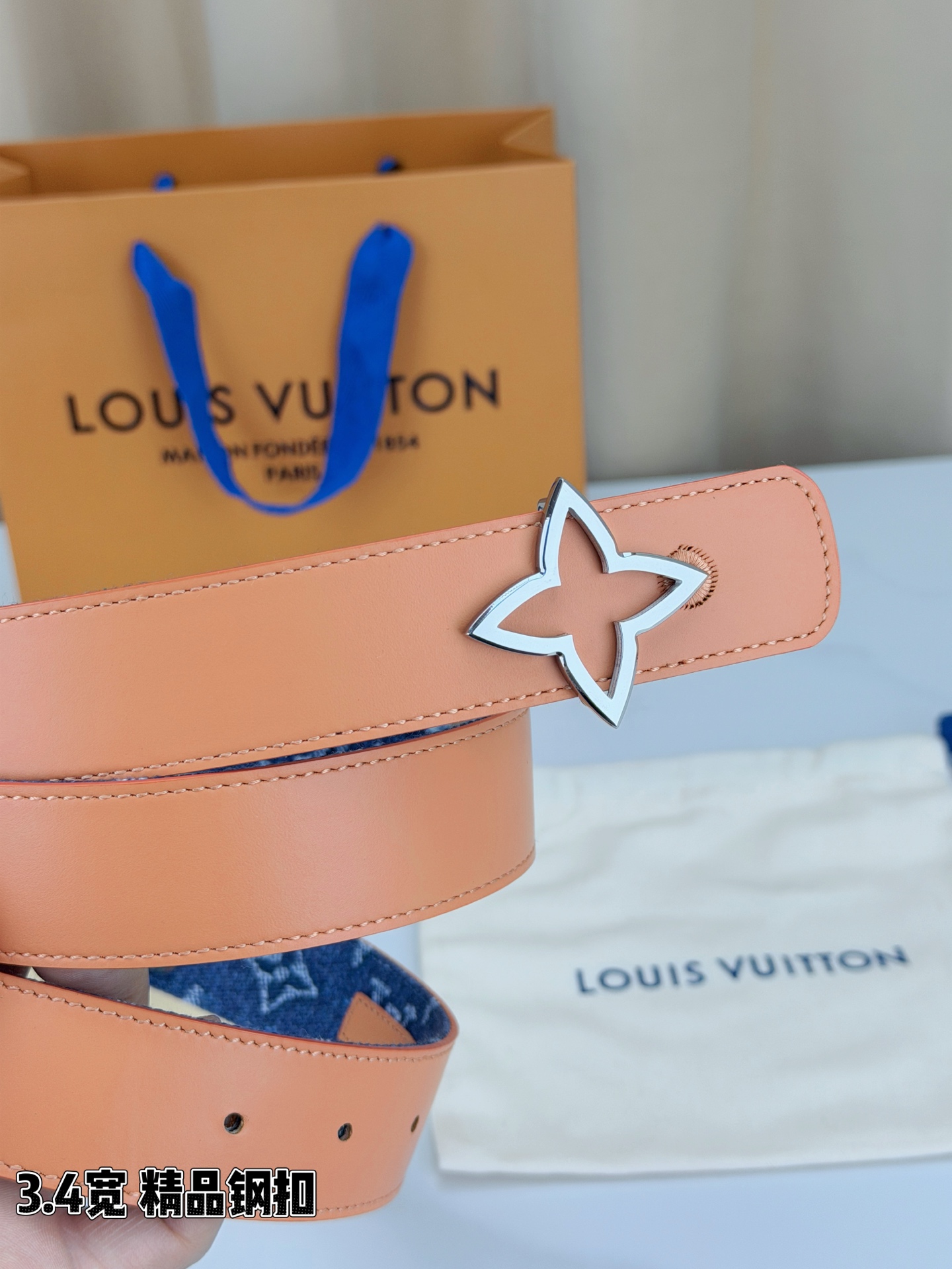 路易威登3.4宽精品钢扣腰带，深蓝牛仔邂逅经典老花，白色LV印记与浅橙花朵交相辉映。镂空四叶花扣金色华贵