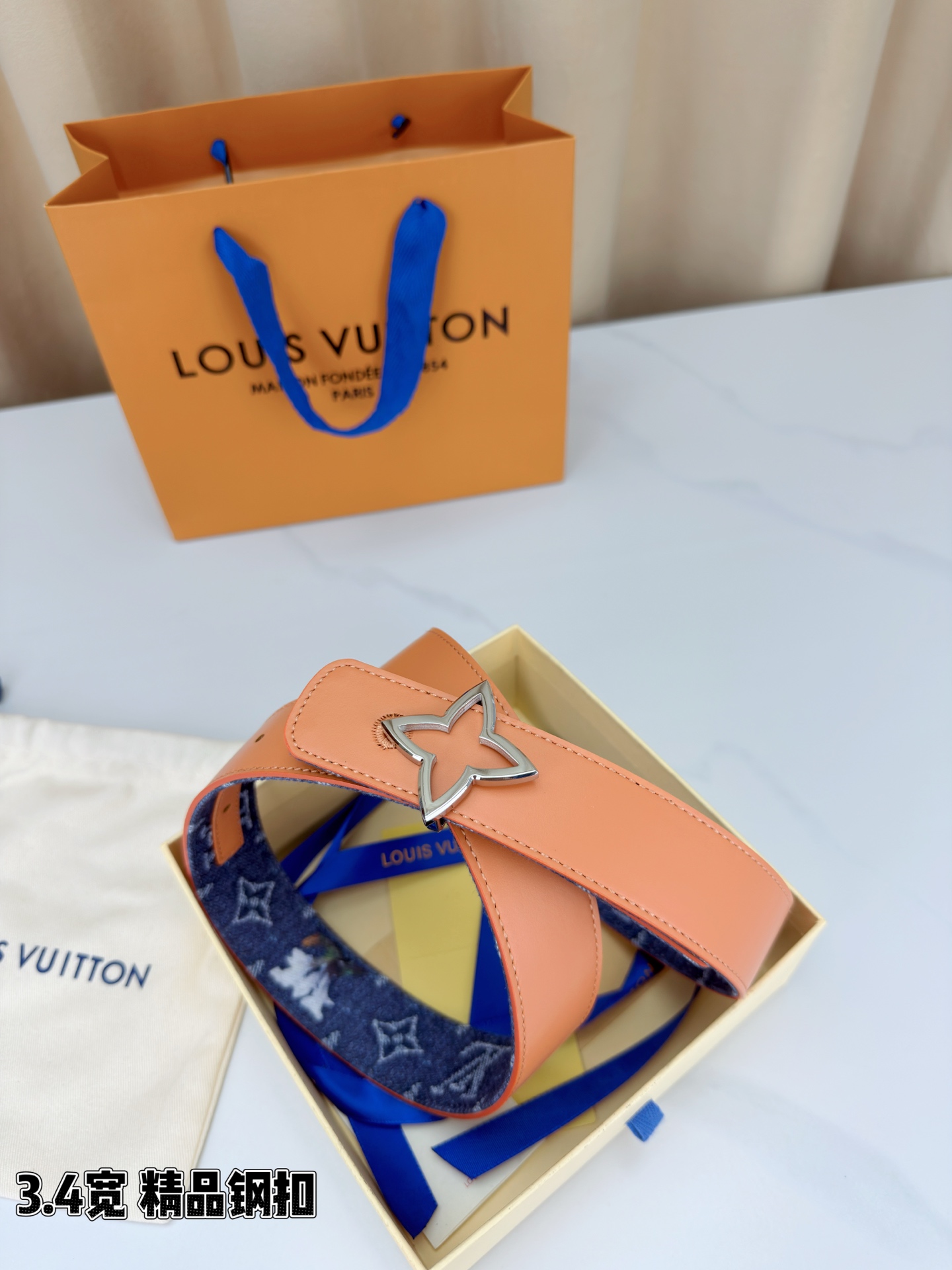 路易威登3.4宽精品钢扣腰带，深蓝牛仔邂逅经典老花，白色LV印记与浅橙花朵交相辉映。镂空四叶花扣金色华贵