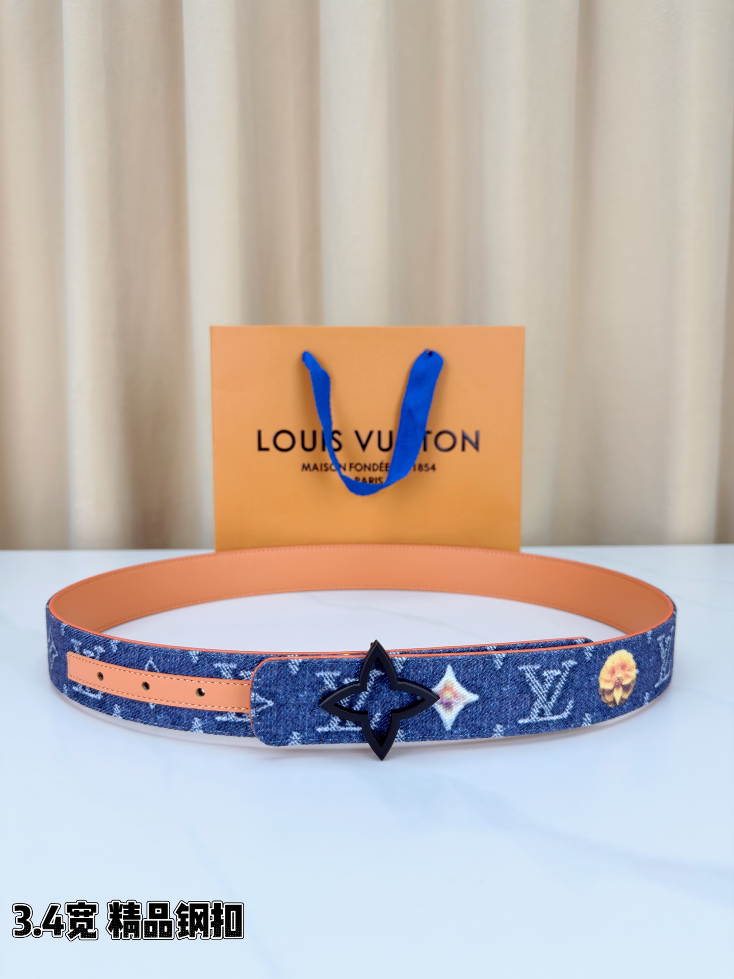 路易威登3.4宽精品钢扣腰带，深蓝牛仔邂逅经典老花，白色LV印记与浅橙花朵交相辉映。镂空四叶花扣金色华贵
