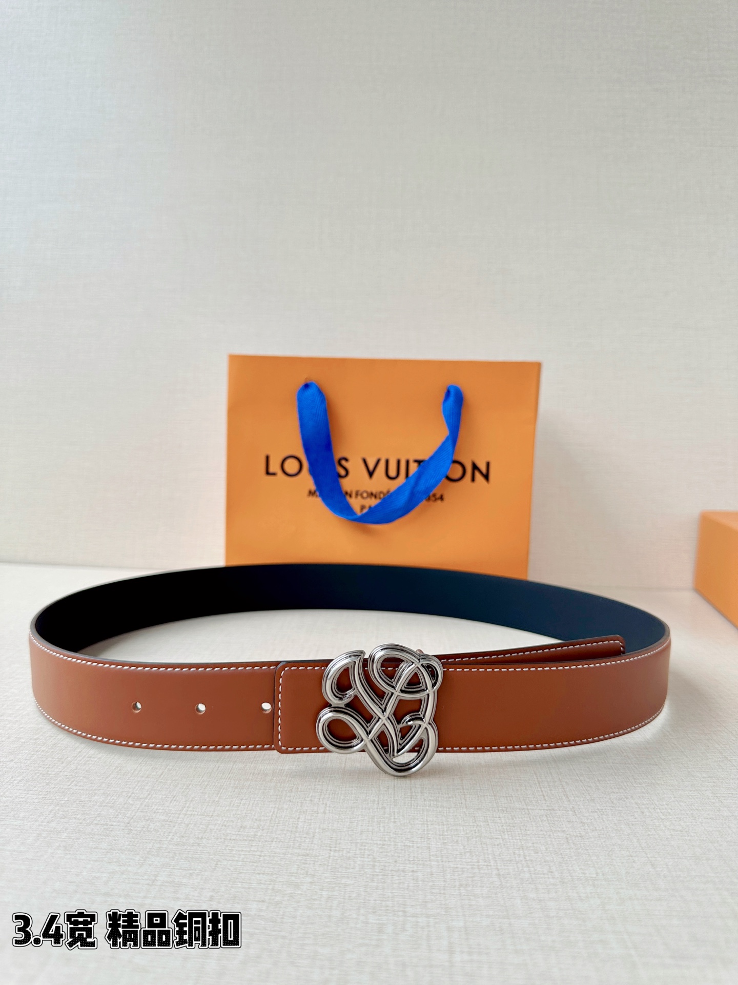 3.4宽 LV Dynasty 双面腰带选用光滑皮革塑造正反两面，以耀目黄铜搭扣呈现 L 和 V 字母的