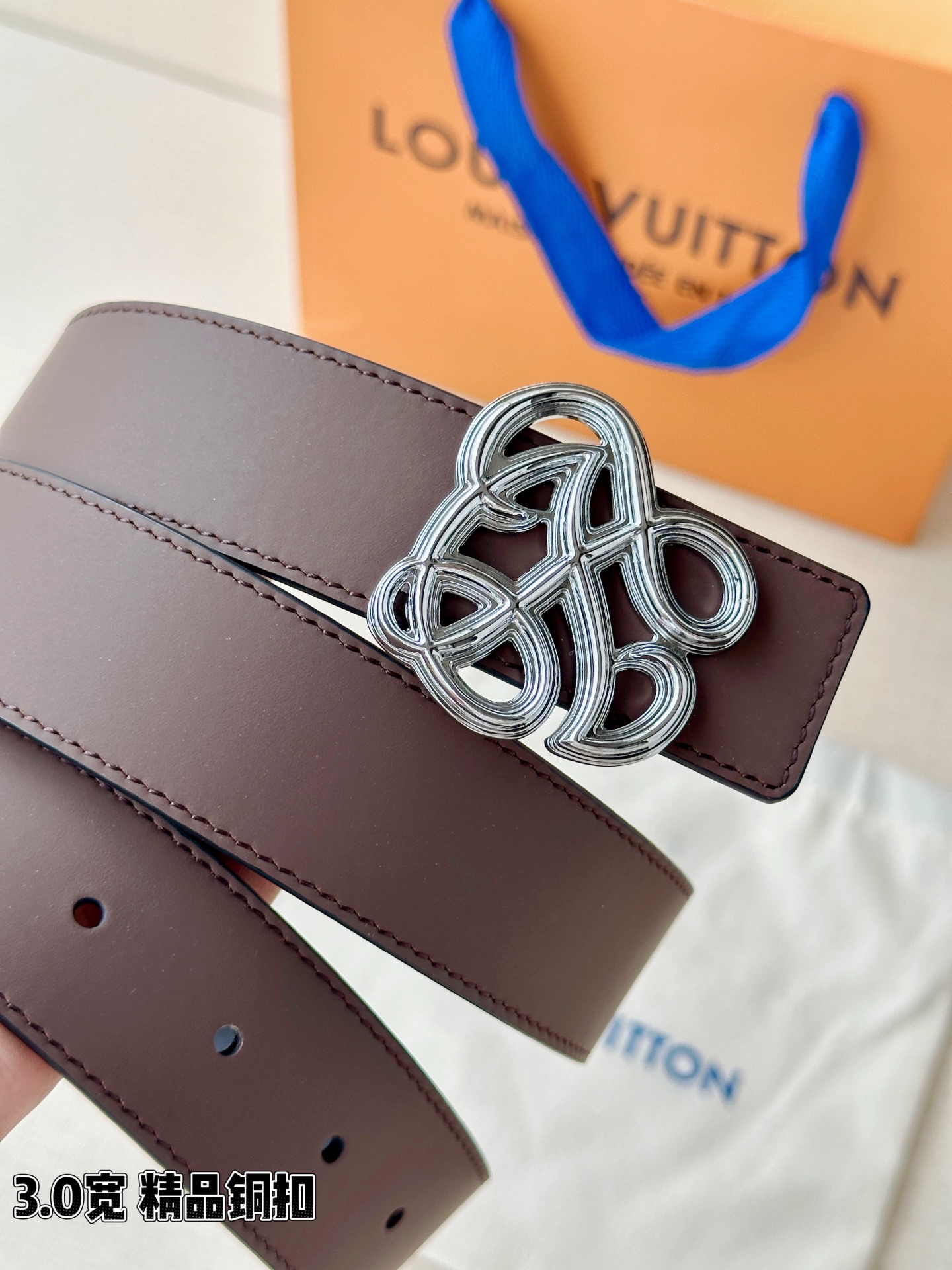3.4宽 LV Dynasty 双面腰带选用光滑皮革塑造正反两面，以耀目黄铜搭扣呈现 L 和 V 字母的