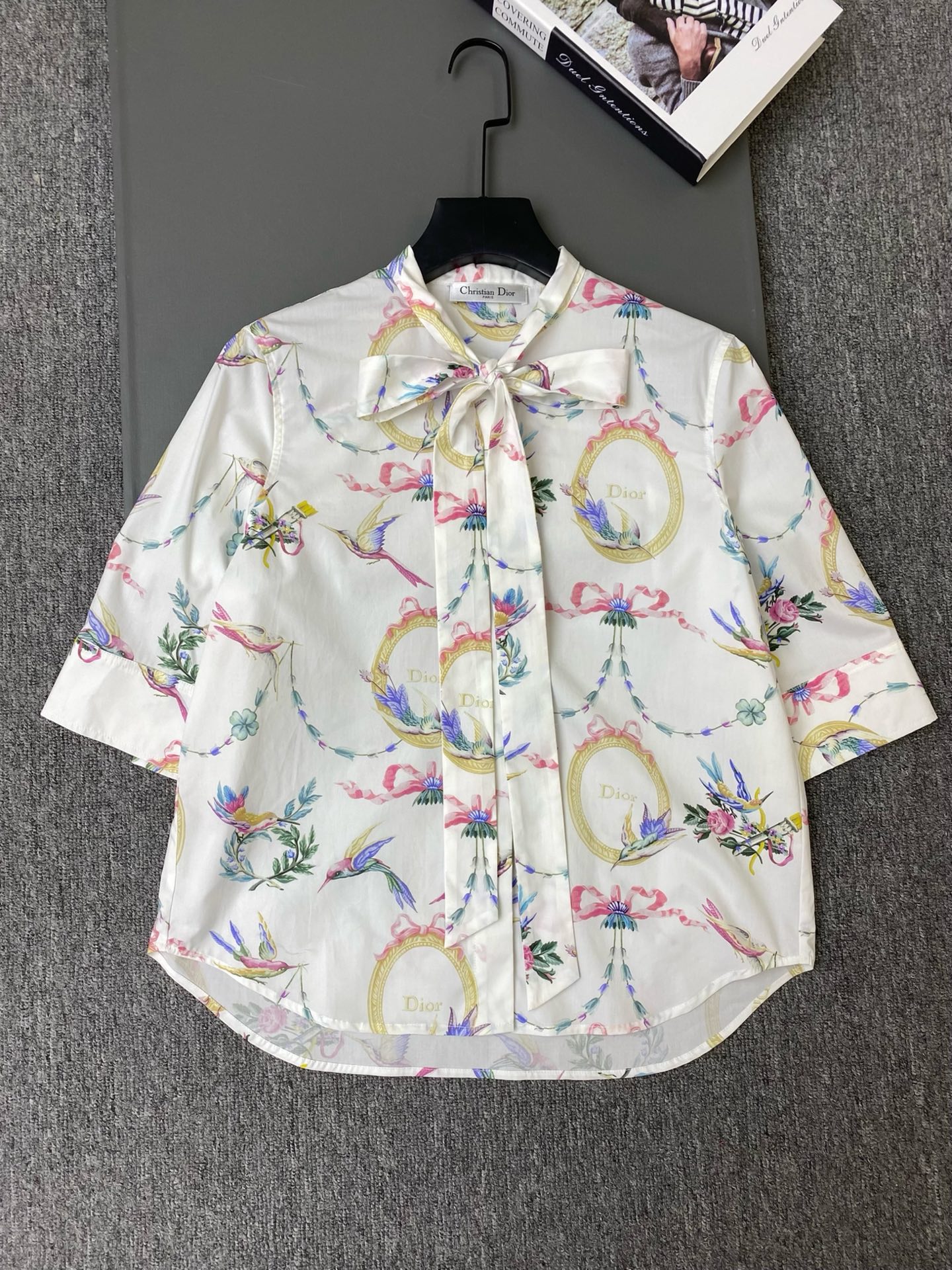NO:941758,Exclusive first release of original quality Di*r 26/new flower and bird print shirt!  Made of high-count cotton fabric, it feels smooth and breathable. The neckband design can be tied into an elegant bow, adding a feminine atmosphere; the body is covered with retro frames, birds, flowers, and ribbon prints, and the brand logo is integrated into the pattern, which is rich in art; the neat short sleeves and cuffs, and the hem design that is short in the front and long in the back, modify the crotch line!  SML, Dior-clothing, dior, T-shirt,19860909独家首发原单品质 Di*r 26/新款花鸟印花衬衣！选用高支棉质面料,触感顺滑透气,领口飘带设计,能系成优雅蝴蝶结,增添柔美的氛围感；衣身铺满复古镜框、飞鸟、花卉、缎带印花,品牌标识融入图案,艺术感浓郁；利落短袖袖口,前短后长的下摆设计,修饰胯部线条！SML,迪奥-服装,dior,T-shirt,,Women's clothing