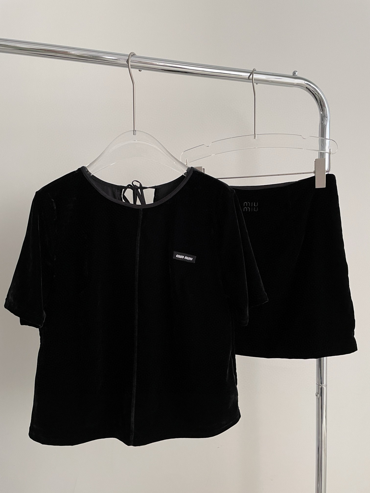 NO:311431,MIUMI* 2025 Early Spring New French rear collar tied velvet logo letter short-sleeved top   short skirt. The entire velvet series is full of retro texture, and the feel is dry and soft and skin-friendly. The black series with the dark velvet luster also makes people look very high-end. The classic round neck is the least picky and most durable choice. The neck is tied with the neckline and the neck is designed with straps, and the sleeves create a smooth shoulder line, and the fleshy arms are hidden. The natural waist does not limit any shape. It is slim and not slim. It is so elegant and amazing when paired with a matching short skirt!  SML, miumiu, skirts, T-shirt, alexander wang19860909MIUMI* 2025 早春新款 法式后领系带丝绒徽标字母短袖上衣 短裙,整个丝绒系列充斥着満満的复古质感,手感干爽柔软亲肤,黑色系搭配丝绒暗暗的光泽感,也衬得人非常高级.经典圆领是最不挑人最耐看的选择,领口后脖颈是做绑带设计,袖形打造流畅肩线,并且隐藏手臂肉肉,自然腰不限制任何身形,修身不勒肉,搭配配套短裙一身太有气质太绝了！ 码数SML,,miumiu,skirts,T-shirt,alexander wang,Women's clothing
