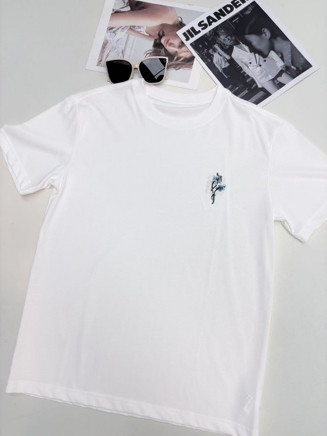 NO:431129,Loewe 2025, new summer style design floral embroidery T-shirt. The solid color is an elegant background color, and the unique breathable weaving method allows every inch of skin to breathe freely, and the high temperature days can keep incredible comfort, dryness and coolness. Say goodbye to the embarrassment of sweating and enjoy the comfort of the summer breeze freely. SML, loewe,tees, t-shirt, alexander wang19860909Loewe 2025 ,夏季新款 设计感花卉刺绣T恤 纯色系是优雅底色,拼独特的透气织法,让每一寸肌肤都能畅快呼吸,高温天也能保持不可思议的舒爽干凉.告别汗津津的尴尬,自在享受夏日微风轻拂的惬意. 码数SML,,loewe,tees，t-shirt,alexander wang,Women's clothing