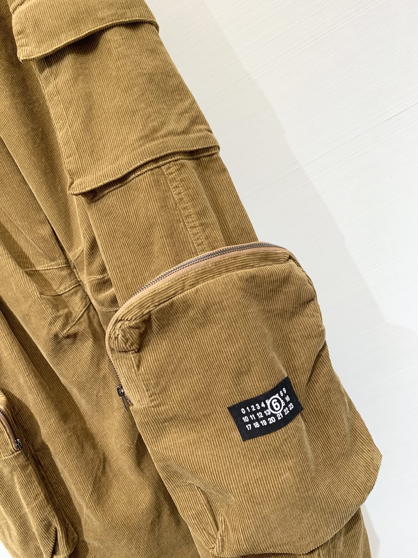 MM6 2025早秋新款 灯芯绒多口袋宽松弯刀工装长裤 极具辨识度的多口袋设计 撞色LOGO点缀 宽松阔