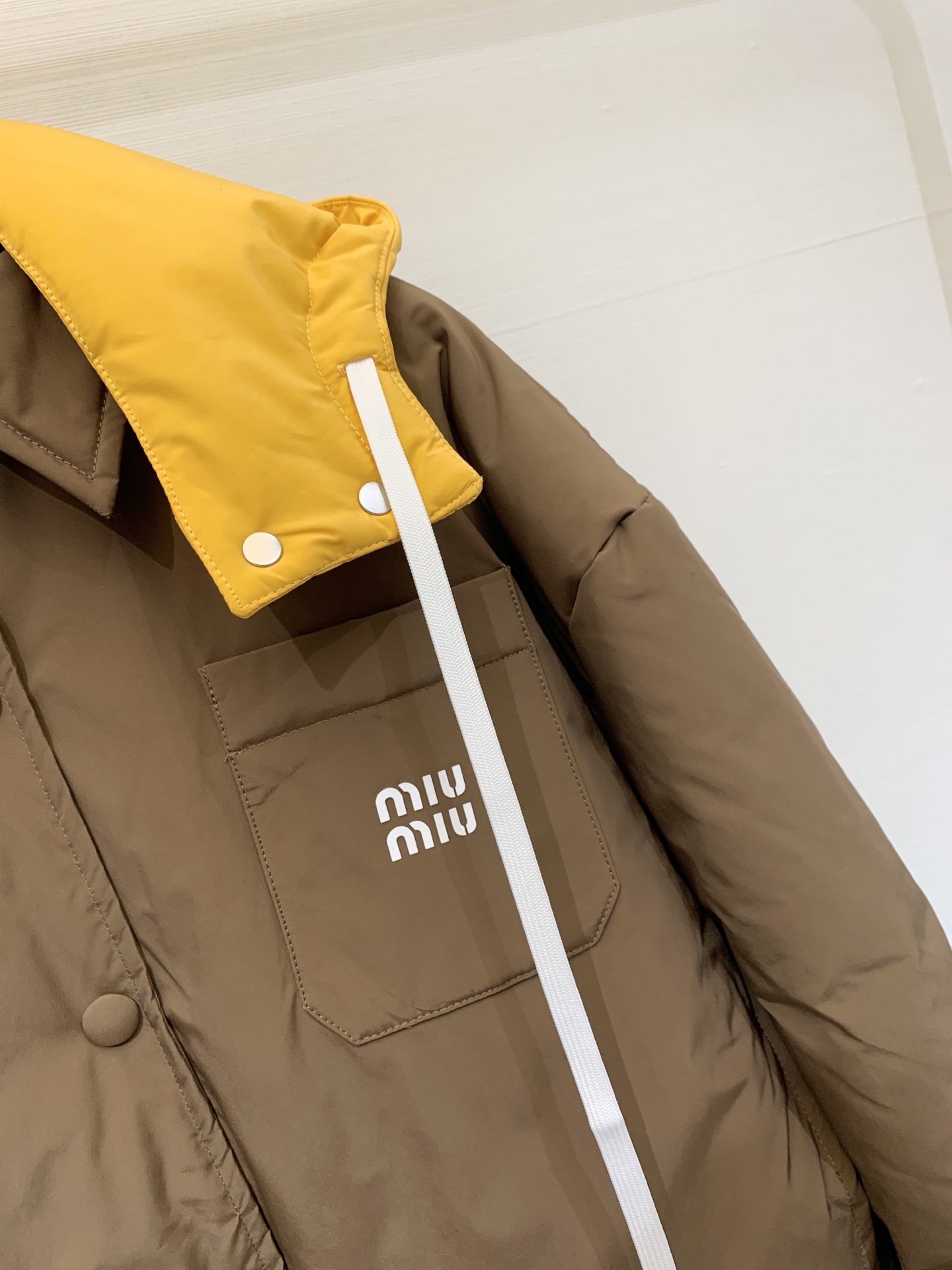 MIUMI* 25秋冬新款 可拆卸连帽翻领羽绒服外套 深棕主色调复古又高级 亮黄色连帽部分瞬间点亮整体 