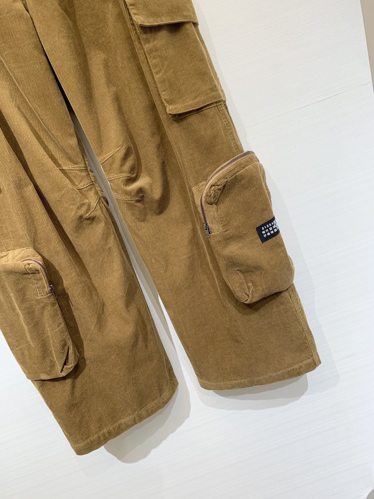 MM6 2025早秋新款 灯芯绒多口袋宽松弯刀工装长裤 极具辨识度的多口袋设计 撞色LOGO点缀 宽松阔