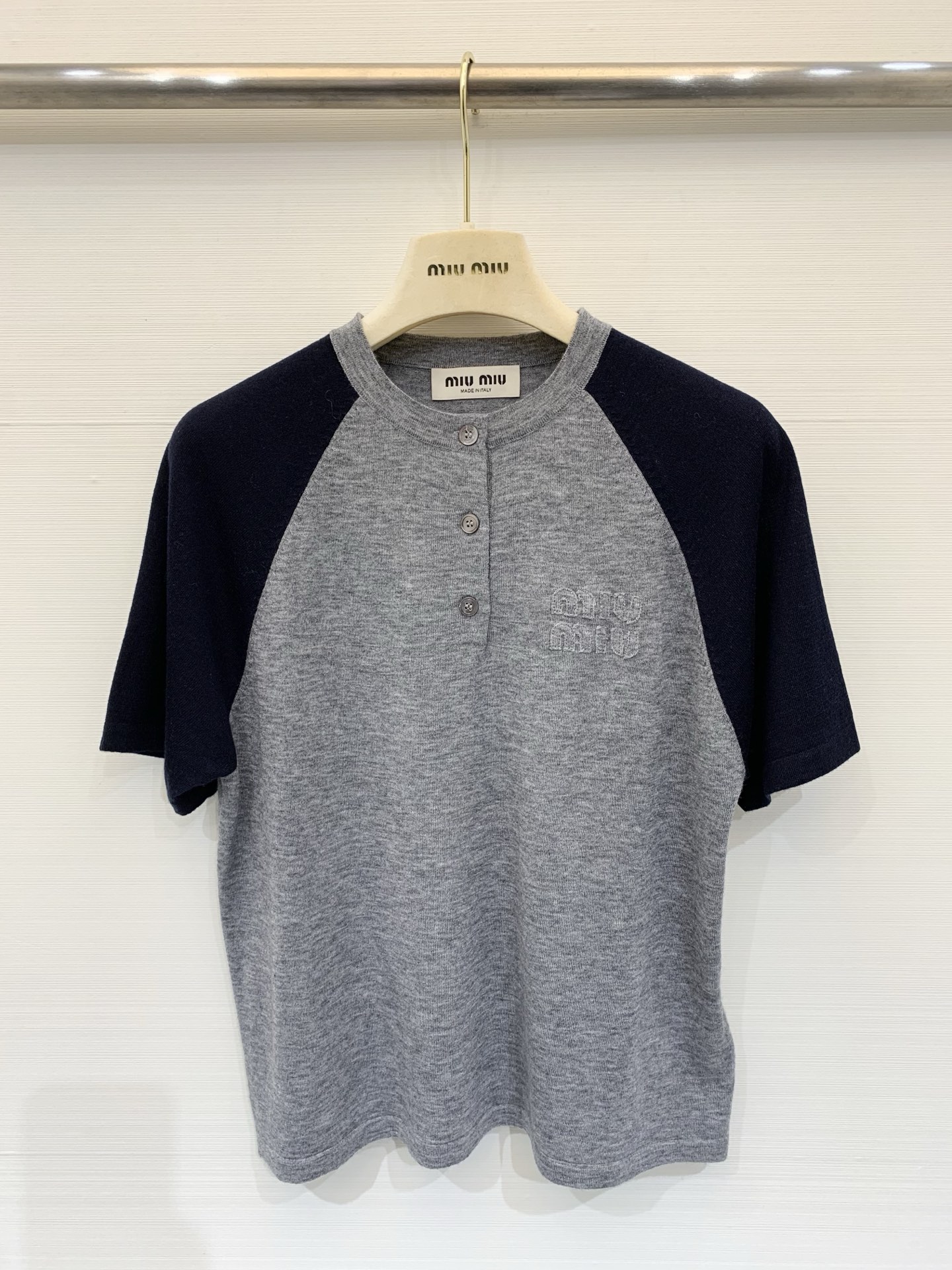 NO:733761,Miu 26 new spring style color-blocked short-sleeved knitted T-shirt. Classic baseball jersey splicing design. Gray body with dark blue sleeves. The brand's iconic brand letter embossed logo on the chest. The overall style is simple but still has a sense of design. It is a versatile item in the spring and summer wardrobe that is both fashionable and practical. Whether it is for daily outings or matching looks, it can be easily worn with a high-end feel. Size SML,, miumiu, T-shirt, tees, t-shirt,19860909Miu 26春季新款 拼色短袖针织T恤 经典棒球服拼接设计 灰色主体搭配深蓝色袖子 胸前有品牌标志性品牌字母压印logo 整体风格简约又不失设计感 是春夏衣橱里兼具时髦与实穿的百搭单品 无论是日常出街还是搭配造型,都能轻松穿出高级感 码数SML,,miumiu,T-shirt,tees，t-shirt,,Women's clothing