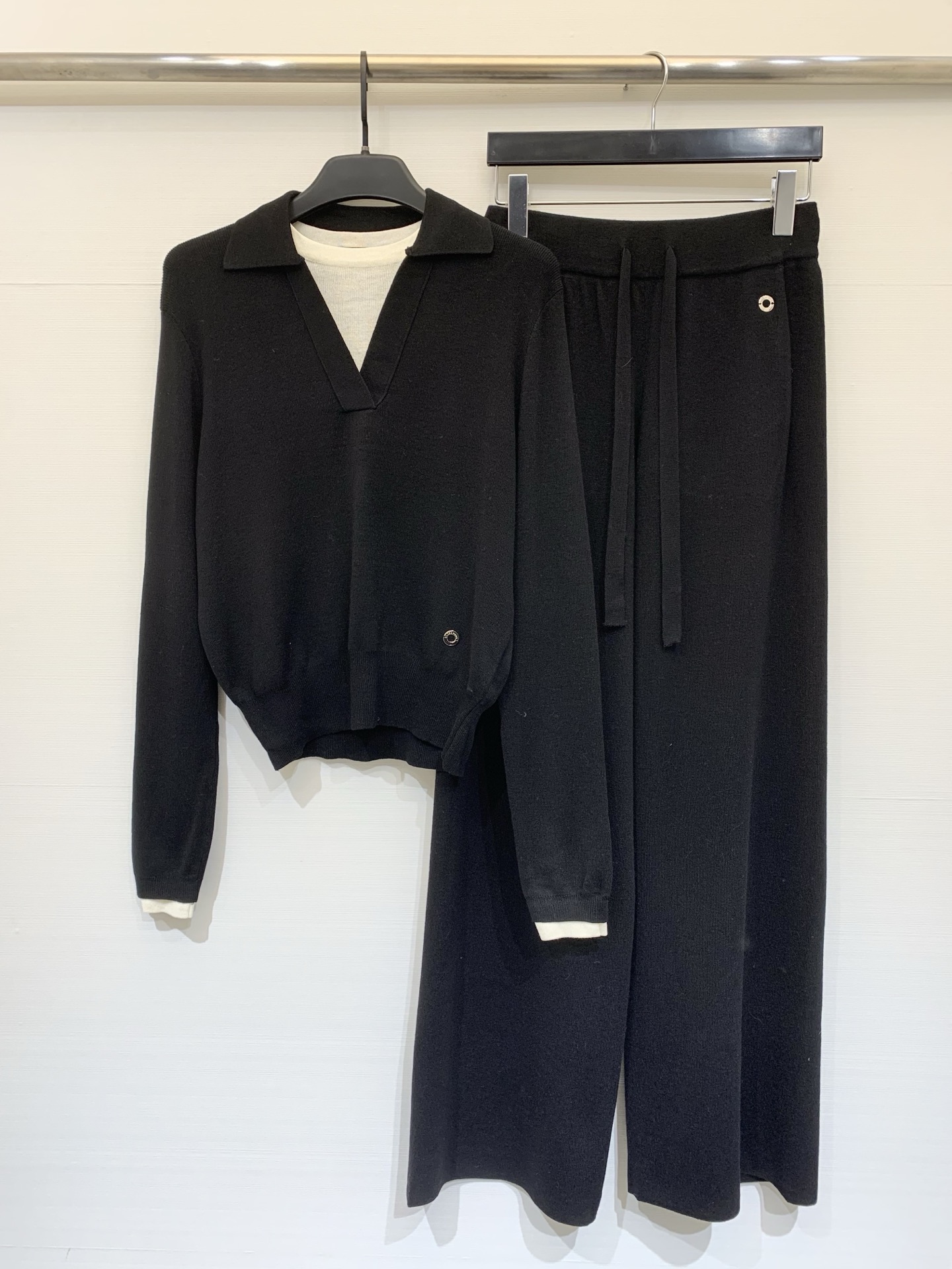 NO:734226,360L 26 early spring new style  The knitted suit is made of delicate and soft knitted fabrics. The fake two-piece lapel sweater and wide-leg knitted trousers have a loose and lazy silhouette as a whole, showing a gentle and advanced casual temperament. The top has an olo collar with a V-shaped placket and a fake two-piece design. The dropped shoulder sleeves are cut to modify the shoulder line, and the short version raises the waistline; the white contrasting edge on the hem and cuffs adds a layer of detail, and the metal buttons on the side  The embellishment enhances the sense of sophistication. The bottoms are high-waisted wide-leg knitted trousers with a drawstring waistband that adapts to a variety of waistlines. The drapey trouser legs modify the leg lines and form a visual unity with the tops in the same color. The whole outfit is soft and skin-friendly without losing shape. Whether it is for home leisure or daily outings, you can easily create a simple and elegant style. Two-color SML, loro  piana,19860909360L 26早春新款 针织套装,采用细腻软糯的针织面料,假两件翻领针织衫阔腿针织长裤,整体为宽松慵懒的廓形,尽显温柔高级的休闲气质,上衣是olo领搭配V字开襟假两件设计,落肩袖剪裁修饰肩线,短款版型拉高腰线；下摆与袖口的白色撞色边增添细节层次,侧边的金属纽扣点缀提升精致感.下装是高腰阔腿针织裤,抽绳腰头适配多种腰围,垂坠感十足的裤腿修饰腿部线条,与上衣同色系的搭配形成视觉统一.整套穿搭柔软亲肤又不失版型,无论是居家休闲还是日常出街,都能轻松打造出简约大气的温柔风造型.两色SML,,loro piana,,Women's clothing