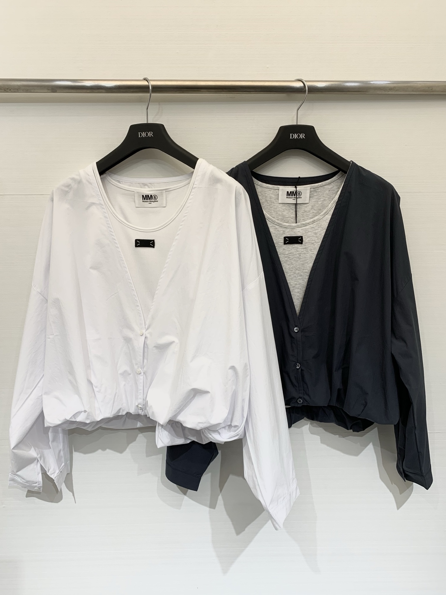 NO:737516,MM6 2026 Spring and Summer New Style Fake two-piece stacking shirt, minimalist deconstruction style. The fake two-piece design breaks the monotony of traditional shirts to create a relaxed and layered daily look, suitable for commuting, leisure and other scenes. The outer layer is a loose-fitting white cotton shirt, and the inner layer is a round-neck knitted inner layer of the same color. There is a small black mark on the collar to enhance the visual effect of layering. Two-color SM, masion margiela, shirts,19860909MM6 2026春夏新款 假两件式叠穿衬衣,极简解构风,通过假两件设计打破传统衬衫的单调感,打造出松弛又有层次的日常造型,适配通勤、休闲等多种场景,外层为宽松廓形的白色棉质衬衫,内层为同色系圆领针织内搭,领口处有黑色小标点缀,强化叠穿视觉效果 两色SM,,masion margiela,shirts,,Women's clothing