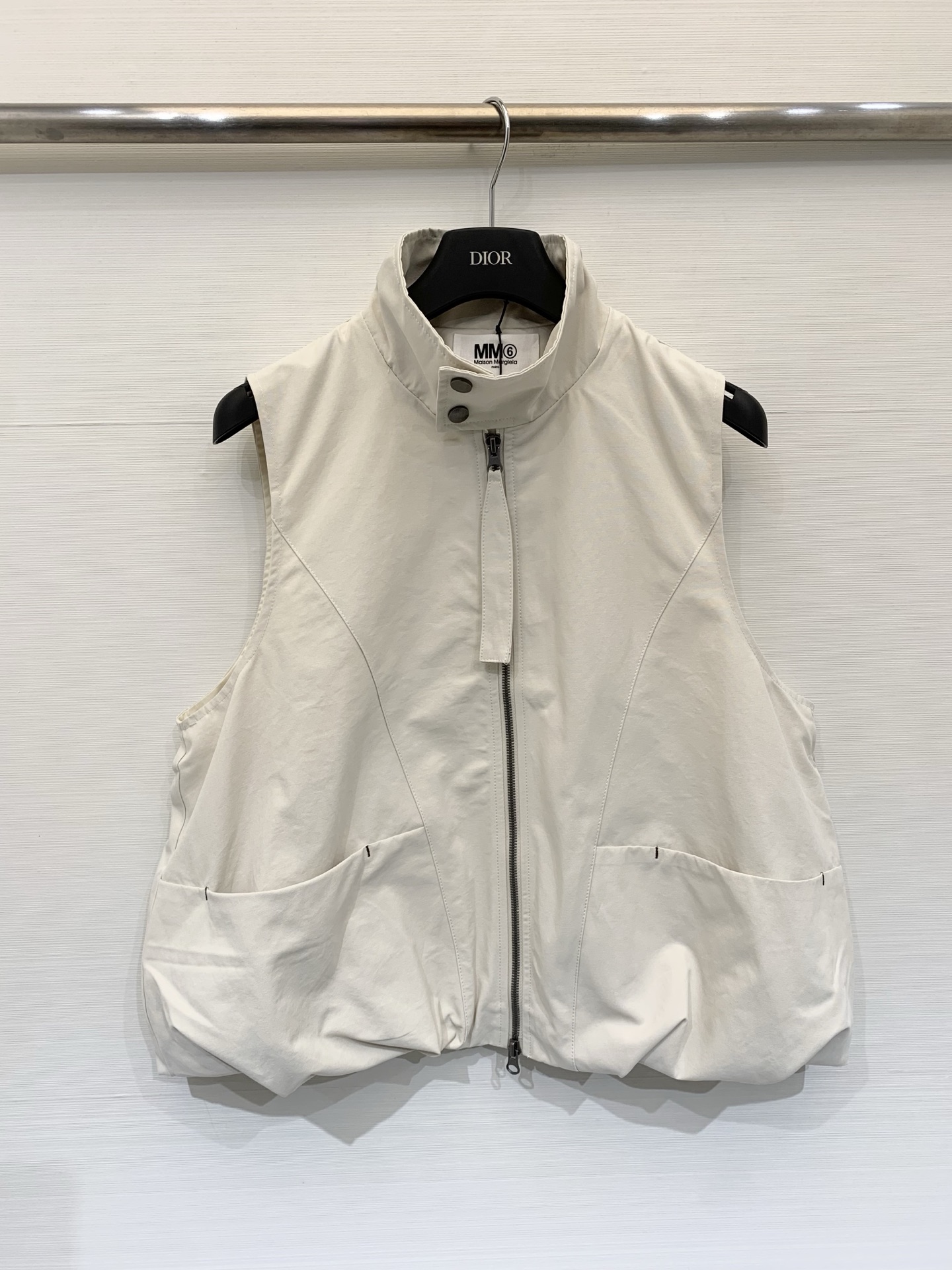 NO:737858,MM6 26 spring and summer new series style sleeveless topstitch work vest. The fusion of minimalist deconstruction style and street work wear style, with a cool and relaxed atmosphere. The body has a full cocoon-shaped silhouette, and the hem is naturally gathered with pleats through shirring design, creating a casual yet structured visual effect. Two-color sml, masion margiela,19860909MM6 26春夏新款 系列款 无袖明线工装马甲 极简解构风与街头工装感的融合,自带酷感与松弛氛围,衣身呈饱满的茧型轮廓,下摆通过抽褶设计形成自然的褶皱收束,营造随性又不失结构感的视觉效果 两色sml,,masion margiela,,Women's clothing