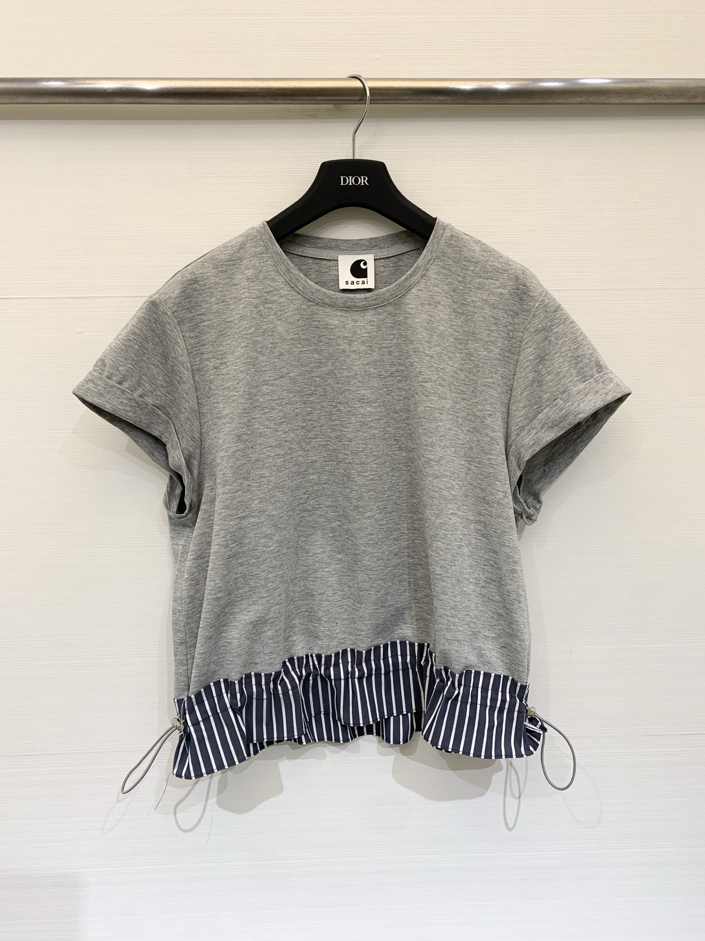 NO:795826,Sacai 26 spring and summer new style pleated hem sleeve T-shirt, the cuffs are naturally rolled, the bottom is spliced ​​with blue and white pinstripe shirt fabric, and a drawstring design is added in the middle. When the drawstring is tightened, the fabric forms a natural pleated/pleated effect, swaying like a small skirt, which not only covers the flesh but also adds a sweet and playful feminine temperament, breaking the monotony of solid color T-shirts. Three-color SM,,skirts,shirts,tees,t-shirt,19860909Sacai 26春夏新款 抽褶下摆坎袖T恤,袖口做了自然的卷边处理,底部拼接蓝白细条纹衬衫面料,中间加入抽绳设计,抽绳收紧时,面料形成自然的百褶/抽褶效果,如同小裙摆般摇曳,既遮肉又增添了甜美俏皮的女性化气质,打破了纯色T恤的单调 三色SM,,skirts,shirts,tees，t-shirt,,Women's clothing