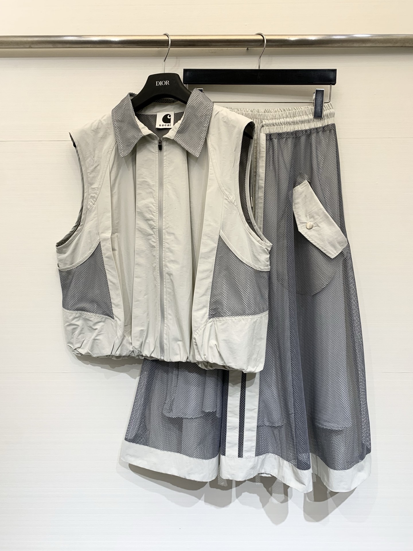 NO:799365,Sacai 26 spring and summer new style spliced mesh vest skirt suit, which has both a workwear feel and a lightness. It is designed with mesh + nylon splicing. The outer layer of the skirt is dark gray mesh, and the inner layer is matched with a light gray lining to create a see-through layering. It has workwear-style pockets (with buttons of the same color), with contrasting vertical strips on the side. A-line mid-length, mid-calf length, the mesh material is light and elegant, and has the neat feel of workwear.  Two-color SML,,skirts,19860909Sacai 26春夏新款 拼接网纱马甲半裙套装,兼具工装感与轻盈感,采用网纱+尼龙拼接设计,半裙外层为深灰色网纱,内层搭配浅灰色内衬,打造透视层次感,带有工装风口袋（带同色系纽扣）,侧边带有撞色竖条拼接,A字中长款,长度及小腿中部,网纱材质轻盈飘逸,同时兼具工装的利落感 两色SML,,skirts,,Women's clothing