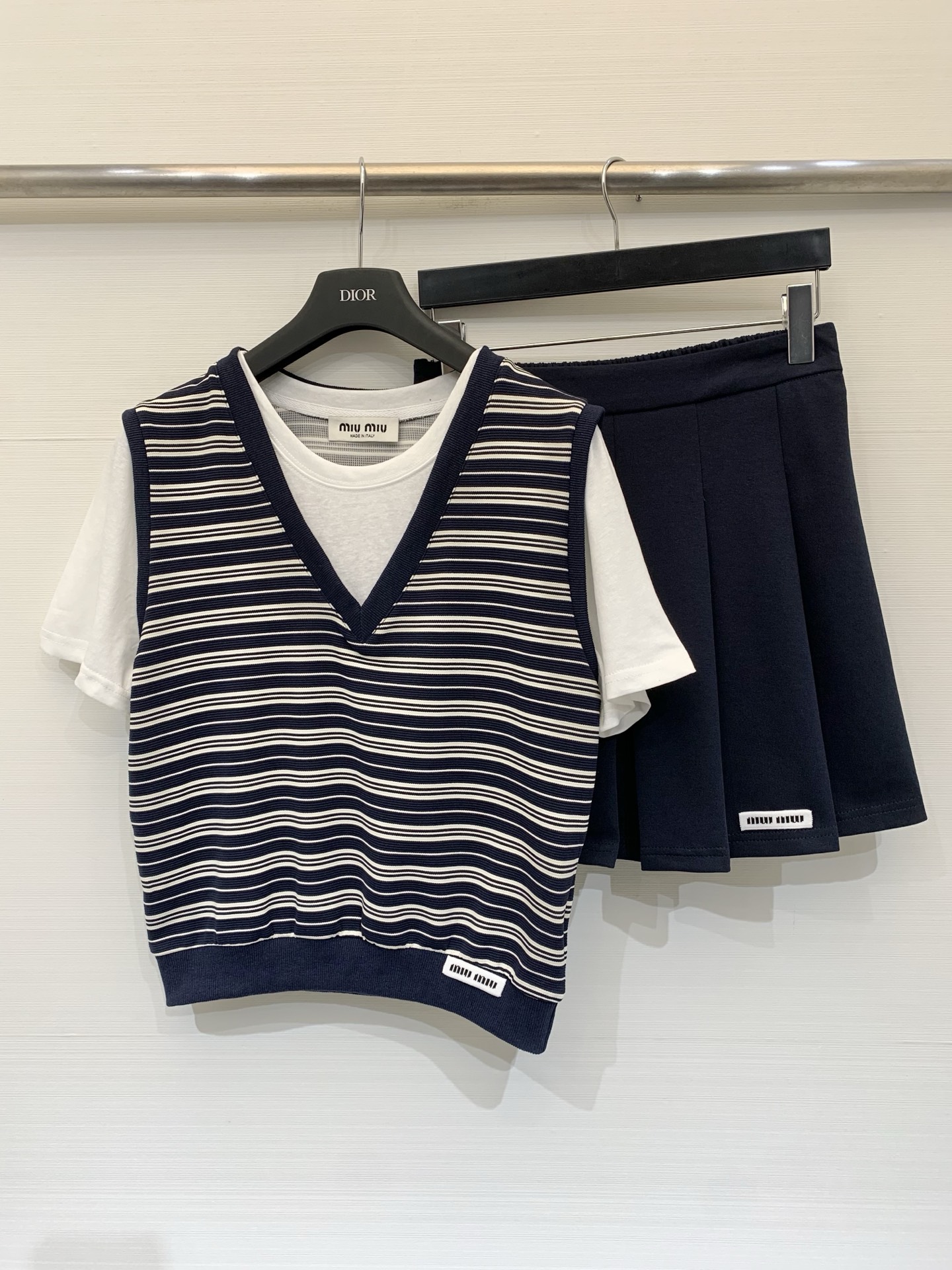NO:807913,MIUMI* 26 new summer style striped fake two-piece skirt suit, navy V-neck horizontal stripes spliced ​​off-white short-sleeved fake two-piece T-shirt, paired with a navy high-waisted pleated skirt of the same color, the overall is a classic 'college age-reducing three-piece suit', suitable for white shoes and loafers, and looks great for daily outings and dates. Size SML P,,miumiu,loafers,skirts,T-shirt,tees,t-shirt,19860909MIUMI* 26夏季新款 条纹假两件半裙套装,藏青V领横条纹拼接米白短袖假两件T恤,搭配同色系藏青高腰百褶短裙,整体是经典的“学院减龄三件套”,搭配小白鞋、乐福鞋都很合适,日常出街、约会穿都很出片 码数SML P,,miumiu,loafers,skirts,T-shirt,tees，t-shirt,,Women's clothing