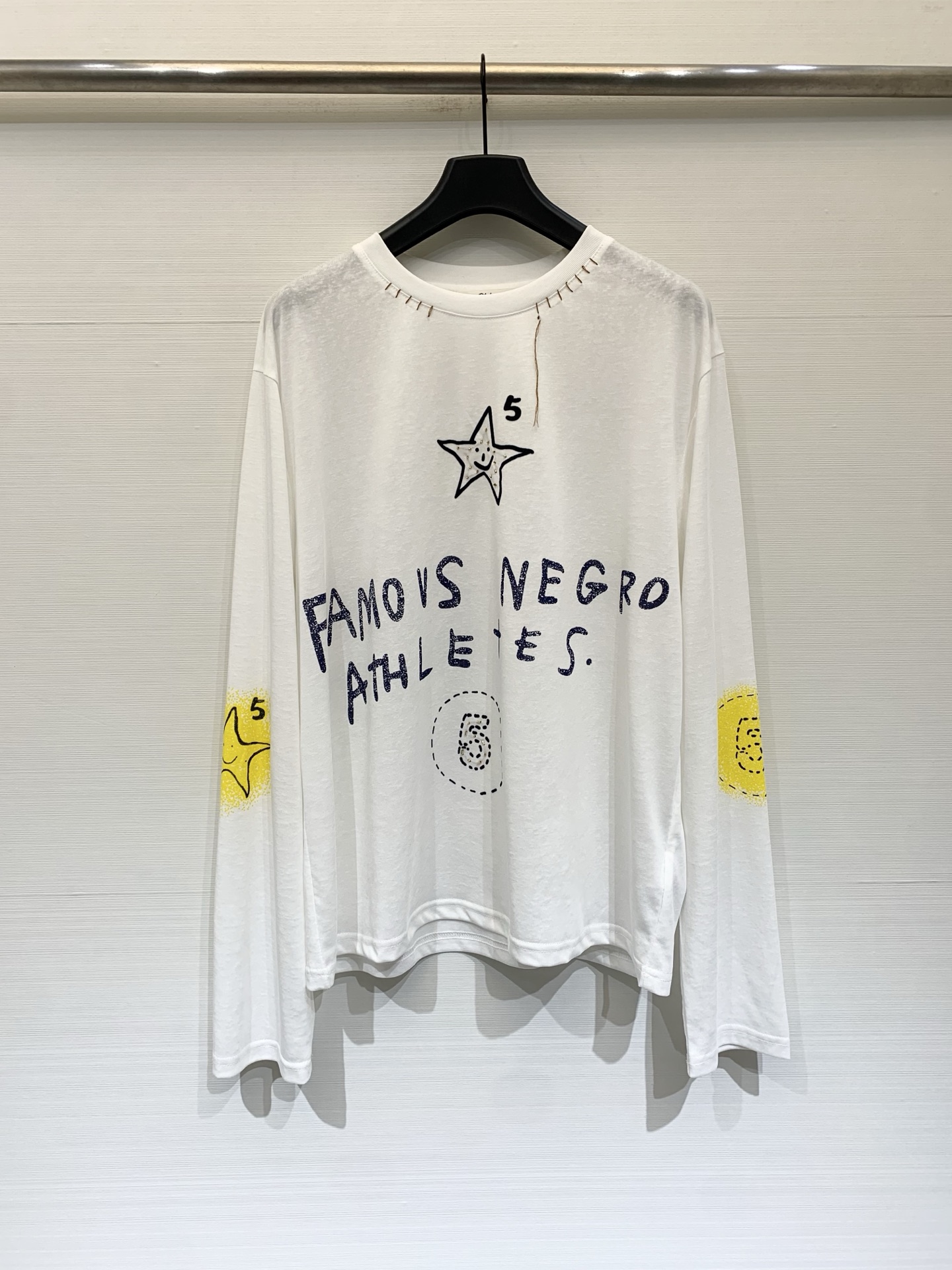 NO:835316,Chloe 26 new summer style hand-painted graffiti sunscreen long-sleeved T-shirt, loose shoulder style, cool and slightly sheer fabric, hand-stitched raw edge design on the neck, hand-painted stars, number '5' and graffiti font 'FAMOUS NEGRO ATHLETES' on the front, with a street feel, suitable for overalls and wide-leg pants, creating a lazy and relaxed feeling. One size fits all, chloe, loewe, tees, t-shirt,19860909Chloe 26夏季新款 手绘涂鸦防晒长袖T恤,宽松落肩款版型,冰凉的微透薄款面料,领口有手工缝线毛边设计,正面手绘风格的星星、数字“5”和涂鸦字体“FAMOUS NEGRO ATHLETES”,自带街头感,适配工装裤、阔腿裤,打造慵懒松弛感 两色均码,,chloe,loewe,tees，t-shirt,,Women's clothing