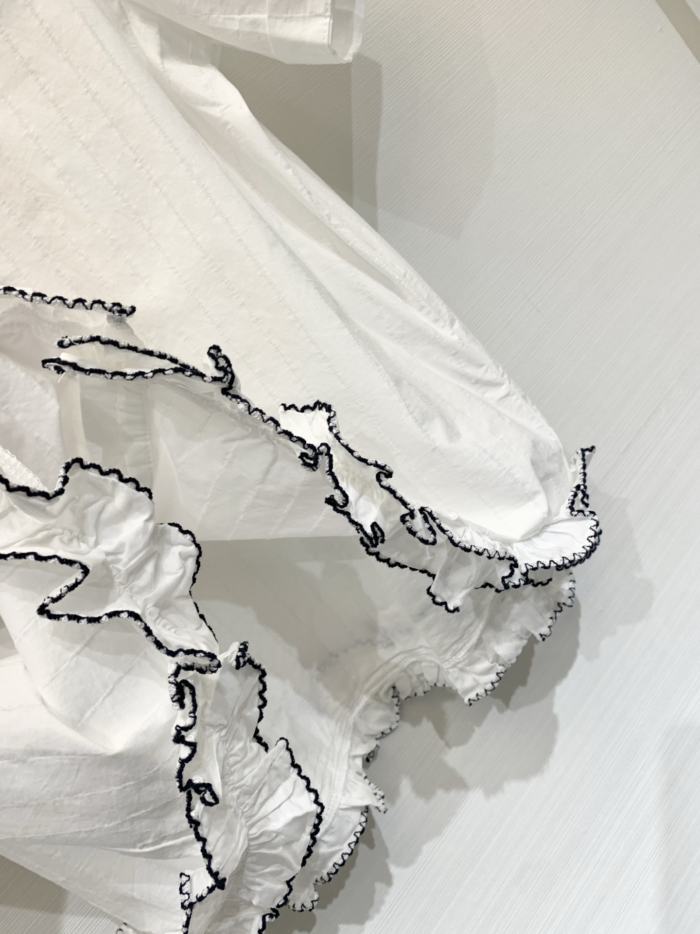Sacai 26夏季新款 联名风短袖衬衫，短款翻领直筒微宽松版型，下摆不规则荷叶边设计，边缘做黑色撞色锁