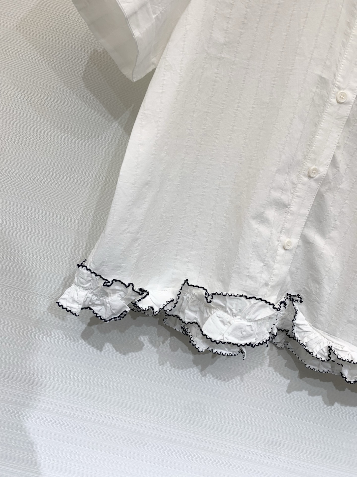 Sacai 26夏季新款 联名风短袖衬衫，短款翻领直筒微宽松版型，下摆不规则荷叶边设计，边缘做黑色撞色锁