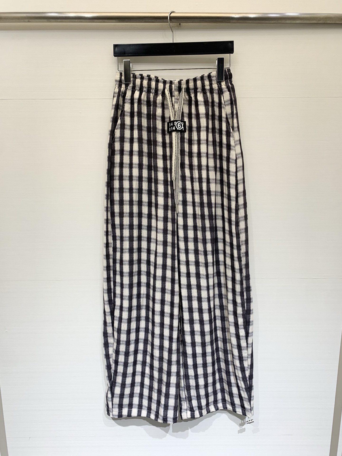 NO:835760,MM6 Maison Margiela 26 new summer style black and white plaid wide-leg pants, black and white plaid texture fabric, elastic waist + drawstring design, with MM6 brand logo on the waistband, loose wide-leg style, with a lazy drape. Pairing with a short top can optimize the proportions, and can also be paired with a long T-shirt to create a 'missing bottom'. It also goes well with vests and suit jackets. It is a representative item of Korean relaxed style. Size SML,,masion  margiela,jackets & coats,tees,t-shirt,business suit,19860909MM6 Maison Margiela 26夏季新款 黑白格纹阔腿裤,黑白格纹肌理面料,松紧腰+抽绳设计,腰头带有MM6的品牌标识标,裤型是宽松阔腿款,自带慵懒的垂坠感,搭配短款上衣能优化比例,也可搭配长T恤打造“下衣失踪”,和马甲、西装外套搭配也很适配,是韩系松弛风的代表单品 码数SML,,masion margiela,jackets & coats,tees，t-shirt,business suit,,Women's clothing