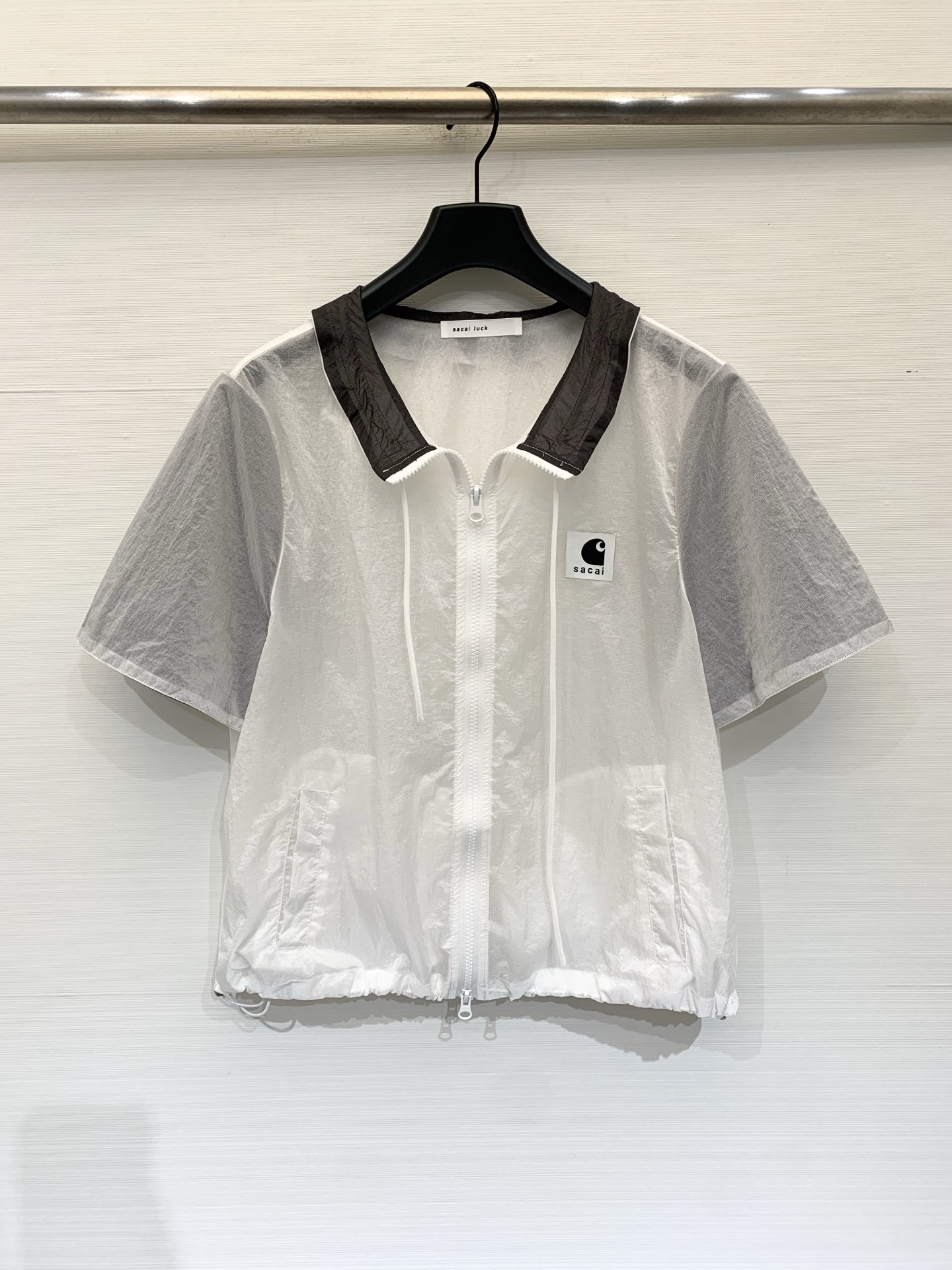 NO:855957,Sacai 26 new summer style color-blocked nylon short-sleeved sunscreen waist shirt, short and slightly loose straight fit, with an adjustable drawstring at the hem, can easily create a high waistline, and is friendly to all body types. The translucent nylon fabric has light and breathable sunscreen properties, and the sense of perspective is just enough to create a 'layered layering'. Two-color SM,, T-shirt,19860909Sacai 26夏季新款 拼色尼龙短袖防晒收腰衬衣,短款微宽松的直筒版型,下摆带可调节抽绳,能轻松打造高腰线,对各种身材都很友好,半透明的尼龙面料,自带轻薄透气的防晒属性,透视感刚好能营造“叠穿层次感” 两色SM,,T-shirt,,Women's clothing