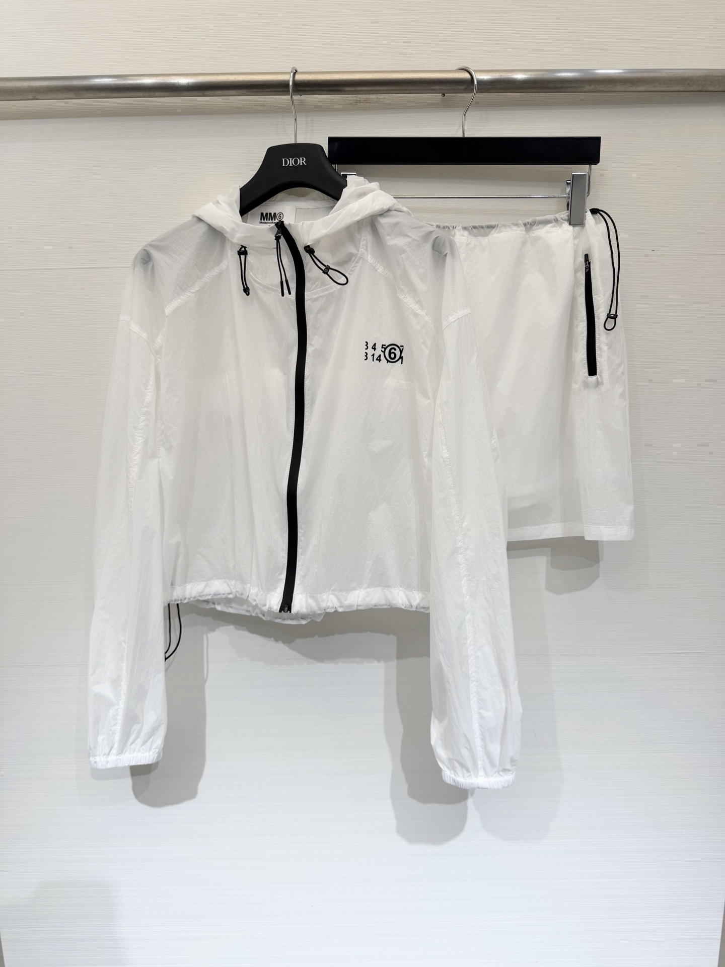 NO:868958,Tops and skirts MM6 Maison Margiela 26 new summer style functional wind sun protection suit (separate), contrasting black main zipper, printed with the brand's iconic digital logo on the chest, made of lightweight ripstop nylon fabric with a slightly wrinkled texture, sun protection, breathable and light waterproof. It is completely stress-free to wear in spring and summer. Whether it is daily outings, commuting or short trips, you can easily wear it with a relaxed and fashionable feeling. Two-color SML, masion  margiela,skirts,19860909上衣 短裙 MM6 Maison Margiela 26夏季新款 机能风防晒套装（分开）,撞色黑色主拉链,胸口印有品牌标志性的数字标识印花,采用轻薄的防撕裂尼龙面料,自带微皱肌理,兼具防晒、透气与轻防水性,春夏穿也完全无压力,不管是日常出街、通勤还是短途出游,都能轻松穿出松弛又时髦的感觉 两色SML,,masion margiela,skirts,,Women's clothing
