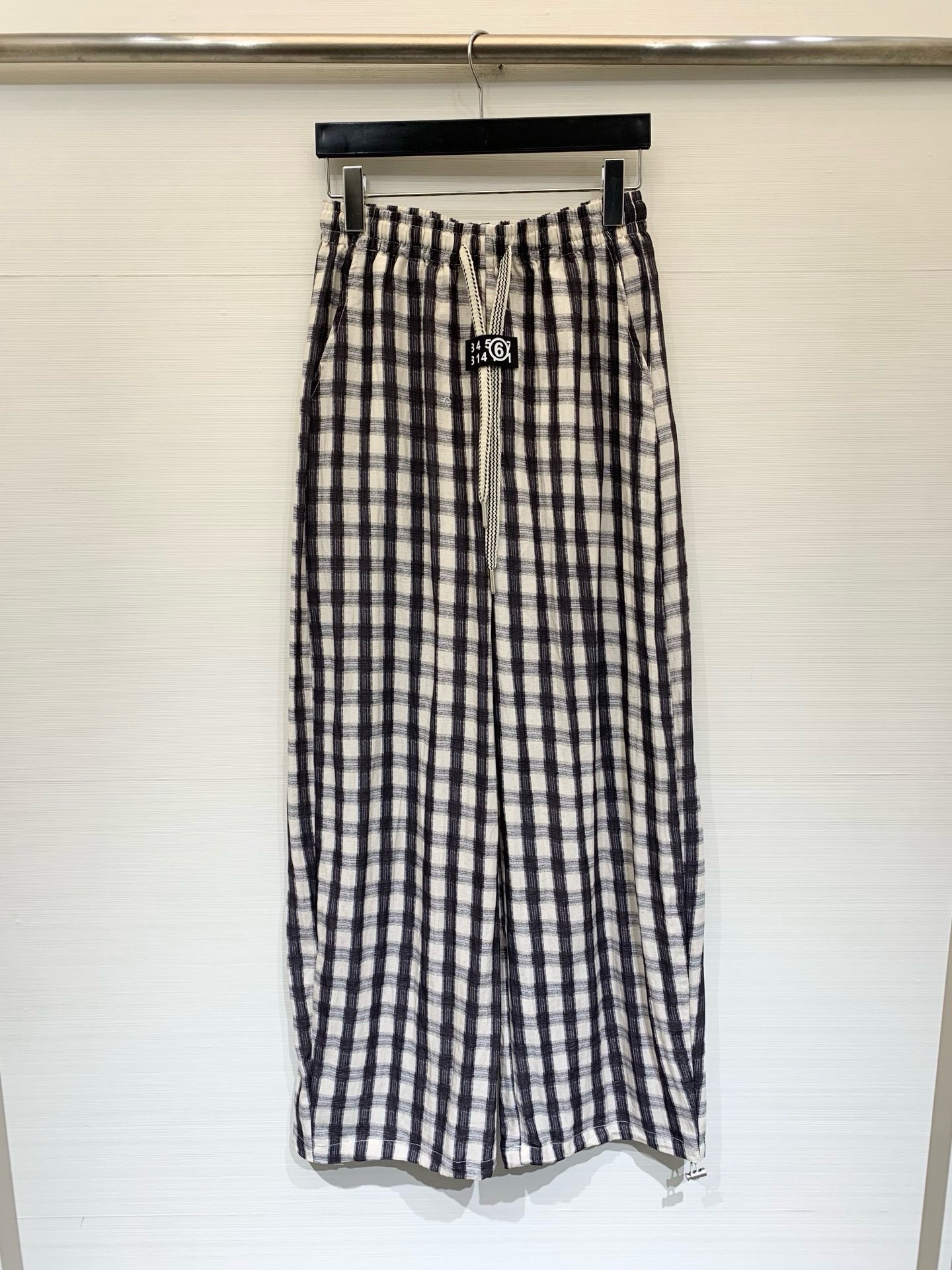 NO:873614,MM6 Maison Margiela 26 new summer style black and white plaid wide-leg pants, black and white plaid texture fabric, elastic waist + drawstring design, with MM6 brand logo on the waistband, loose wide-leg style, with a lazy drape. Pairing with a short top can optimize the proportions, and can also be paired with a long T-shirt to create a 'missing bottom'. It also goes well with vests and suit jackets. It is a representative item of Korean relaxed style. Size SML,,masion  margiela,jackets & coats,tees,t-shirt,business suit,19860909MM6 Maison Margiela 26夏季新款 黑白格纹阔腿裤,黑白格纹肌理面料,松紧腰+抽绳设计,腰头带有MM6的品牌标识标,裤型是宽松阔腿款,自带慵懒的垂坠感,搭配短款上衣能优化比例,也可搭配长T恤打造“下衣失踪”,和马甲、西装外套搭配也很适配,是韩系松弛风的代表单品 码数SML,,masion margiela,jackets & coats,tees，t-shirt,business suit,,Women's clothing