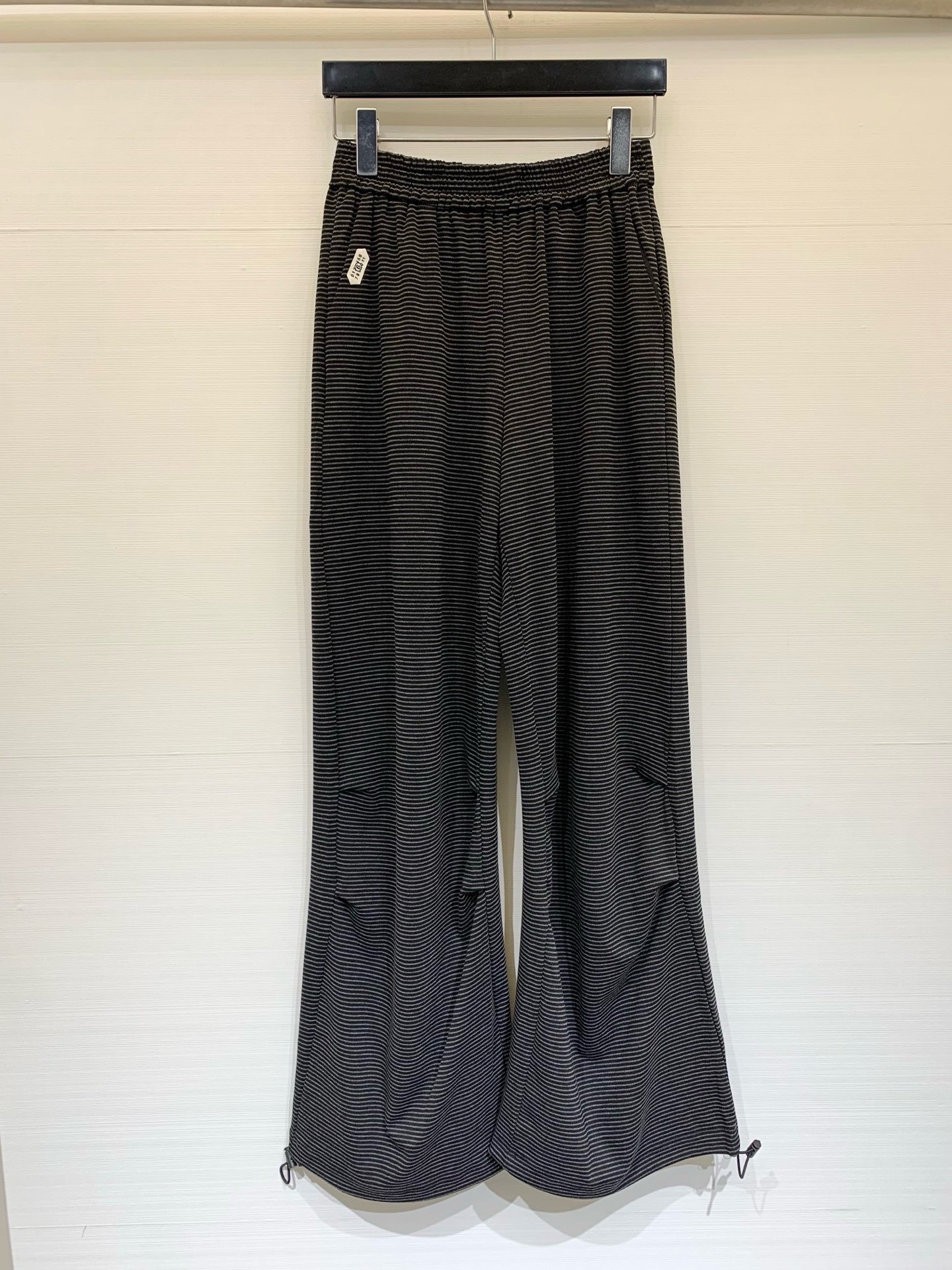NO:873585,MM6 26 spring and summer new style black and gray pinstripe casual trousers with elastic waist, drawstring leg design at the trouser legs, you can freely switch between straight and leg styles, soft and skin-friendly pure cotton fabric, with delicate black and gray pinstripe pattern, with a small white decorative label on the side, comfortable and lazy, focusing on casual sports style, practical for both home and outdoor wear. Size SM, masion margiela,19860909MM6 26春夏新款 黑灰细条纹束脚休闲长裤,松紧腰头,裤脚处设有抽绳束脚设计,可自由切换直筒与束脚版型,软糯亲肤的纯棉面料,带有细腻的黑灰细条纹路,侧边带有一个小巧的白色装饰标,舒适慵懒,主打休闲运动风,兼具居家与外穿的实用性 码数SM,,masion margiela,,Women's clothing