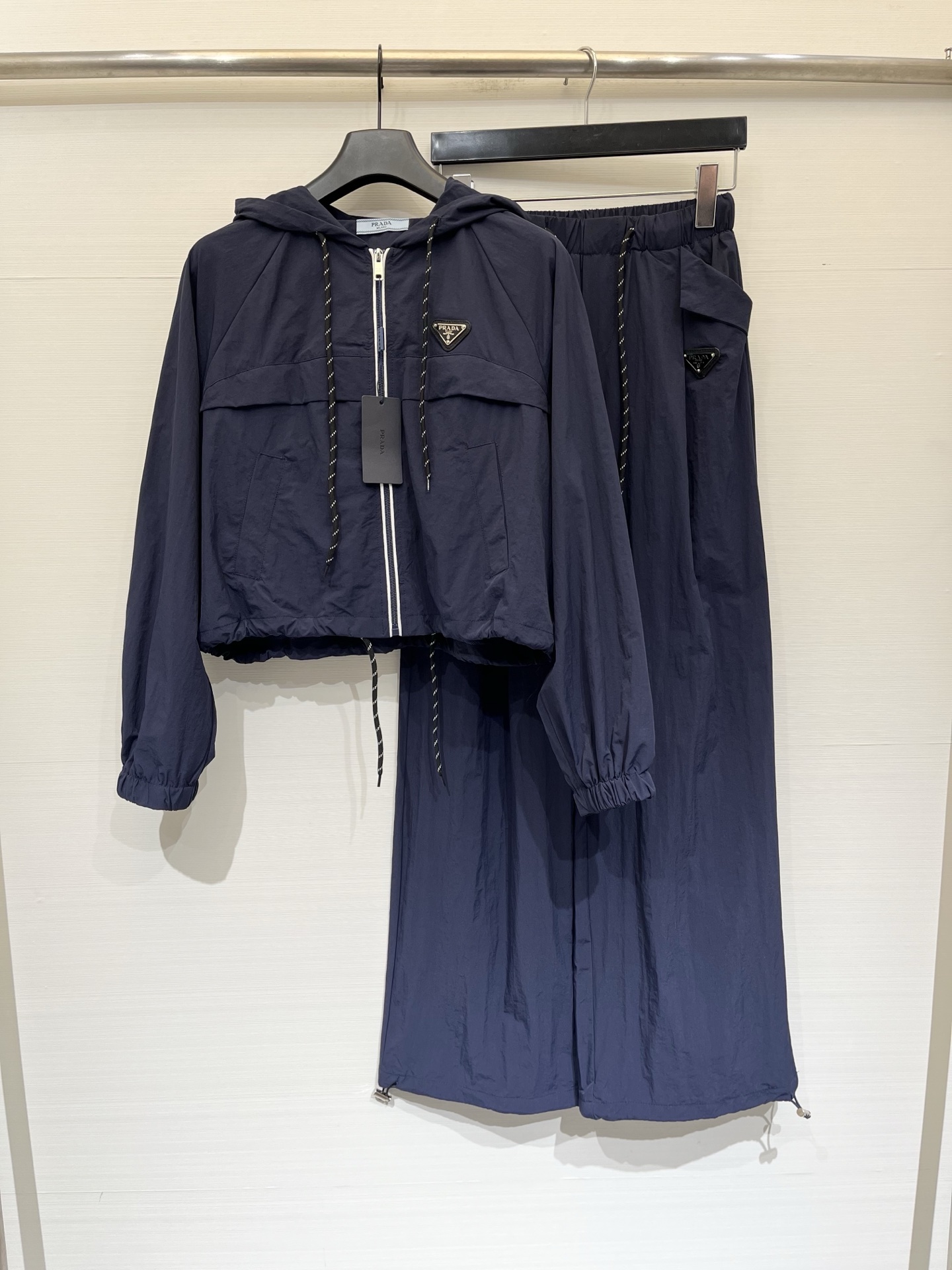 NO:878821,'Prada Triangle Logo Hooded Sun Protection Suit' is sun-protective and slimming. One set can be used for all spring and summer occasions. High-definition nylon fabric, light and breathable. Cropped top + wide-leg pants can change the proportion of 30 to 70 in seconds. Blue and white contrasting drawstring details are full. Can be worn for daily/traveling. Two-color SML, prada, hats,19860909「Prada 三角标连帽防晒套装」 防晒又显瘦,一套搞定春夏所有场合,高定尼龙面料,轻薄透气,短款上衣+阔腿裤,秒变三七分比例,兰白撞色抽绳细节拉满,日常/出游都能搭,两色SML,,prada,hats,,Women's clothing
