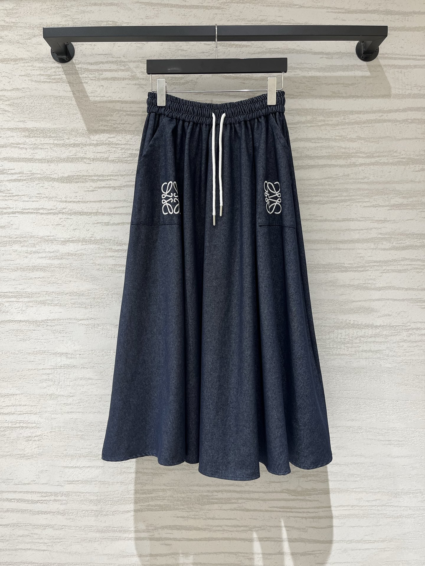 NO:911478,Loewe denim texture A-line skirt, using the brand's iconic Anagram embroidery as the design highlight, navy blue denim fabric with white embroidery, with a relaxed Spanish aesthetic atmosphere, high waist elastic drawstring waistband, with natural texture, it will not be stuffy at all in summer, size SML,,loewe,skirts,19860909Loewe 牛仔质感A字半裙,采用品牌标志性的Anagram刺绣为设计亮点,藏青色牛仔面料搭配白色刺绣,自带松弛的西班牙式美学氛围,高腰松紧抽绳腰头,自带天然肌理感,夏天穿也完全不会闷热,码数SML,,loewe,skirts,,Women's clothing