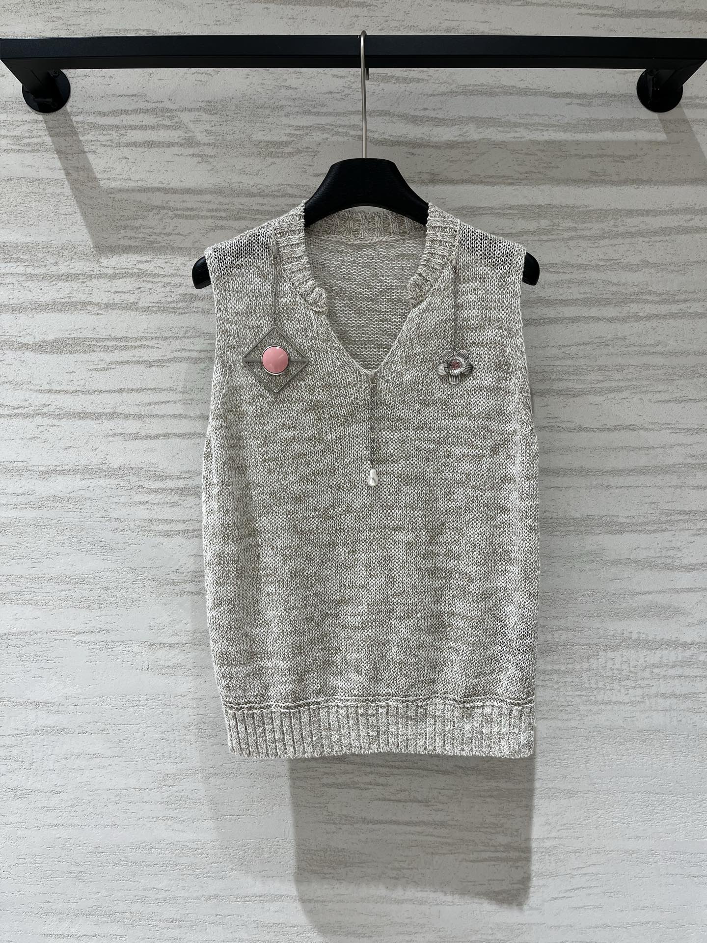 NO:926920,Prada heavy floral knitted sleeveless vest, floral gray (floral yarn texture, gray and white mixed weaving) small V-neck, half-open zipper design on the neckline, small pearl decoration on the zipper puller, rhombus metal frame + pink round buckle on the left shoulder, small flower diamond decoration on the right shoulder, asymmetrical design on the left and right, straight and slightly loose fit, ribbed hem, versatile for daily use, can be worn alone or layered. Two-color SML, prada,19860909Prada 重工花莎针织无袖背心,杂花灰（花纱质感,灰白混织）小V领,领口带半开拉链设计,拉链头坠有小珍珠装饰,左肩菱形金属框+粉色圆形扣饰,右肩小花钻饰,左右不对称设计,直身微宽松版型,下摆罗纹收边,日常百搭,单穿叠穿都可 两色SML,,prada,,Women's clothing