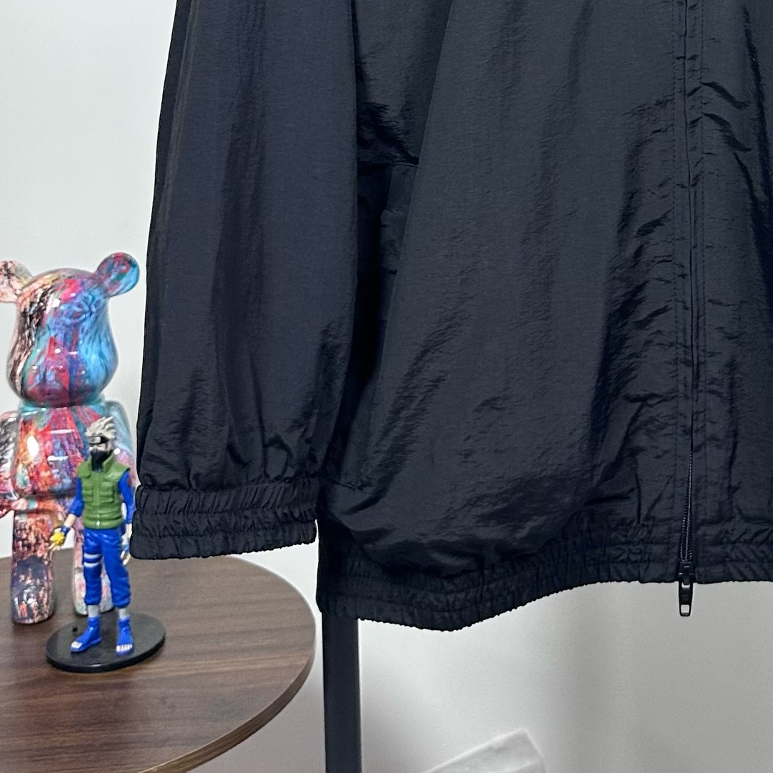 P240
款号：Y08
Balenciaga 巴黎世家新款lion club曼联运动冲锋衣外套-

酷盖必备💥| Balenciaga 曼联刺绣冲锋衣
👦潮流玩家们，Balenciaga 这件黑色曼联刺绣冲锋衣真的杀疯了！
⚫经典黑色，百搭王者段位，怎么搭都不出错，轻松拿捏各种风格。冲锋衣版型挺括有型，穿上身气场瞬间两米八，户外感与时尚感并存。
曼联刺绣无疑是最大亮点👏，传承足球精神的同时，为这件冲锋衣赋予了独特的文化底蕴，精致刺绣在黑色基底上格外惹眼，高级感与个性齐飞。
功能性更是杠杠的👍，专业防水面料，下雨天、户外探险都能应对自如；透气设计让你运动出汗后也能保持干爽。拉链顺滑无阻，多口袋方便收纳随身小物件。 
尺码：S-XL 