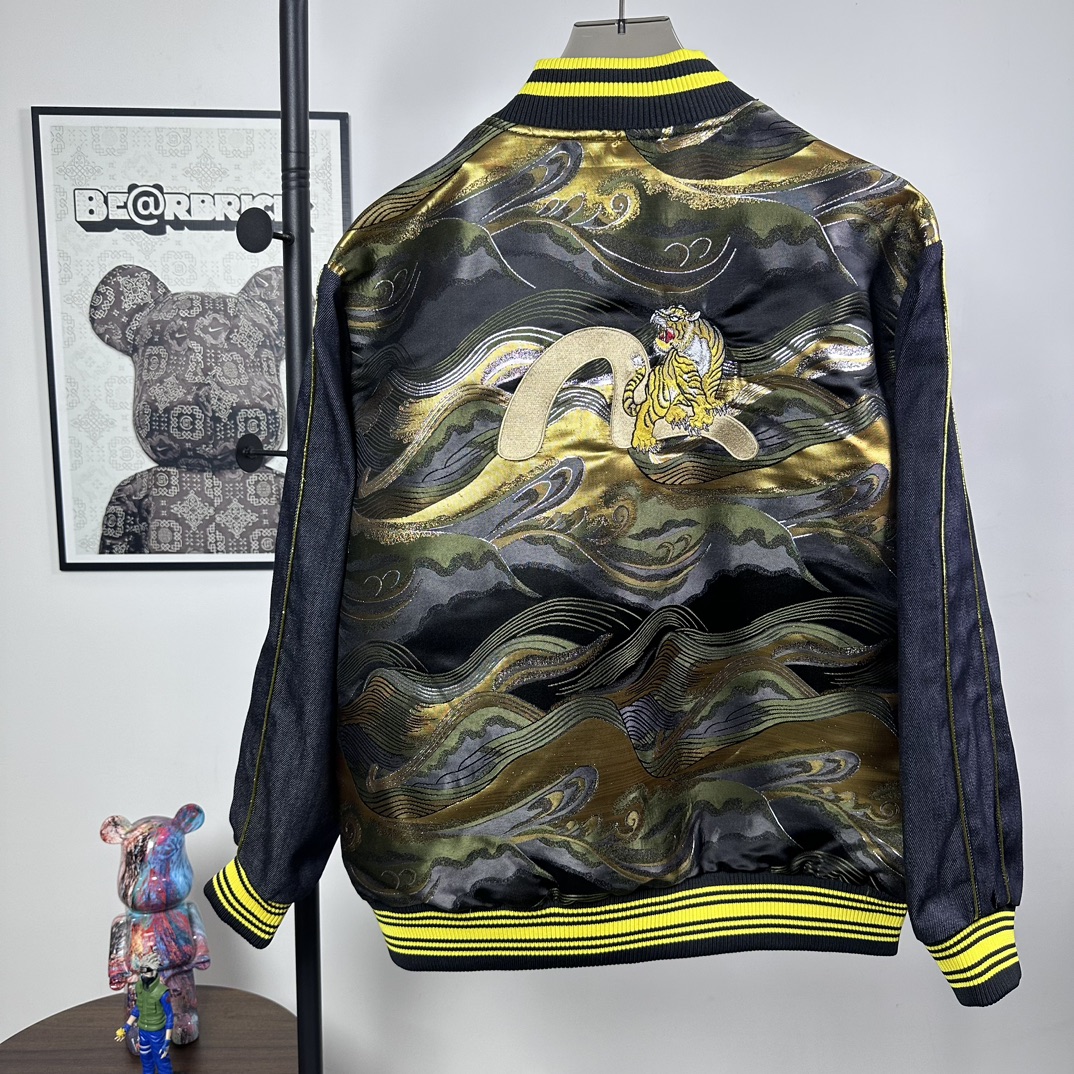 P180
款号：Z49
重磅来袭，新款推荐，EVISU（福神）外套，三标齐全，采用经典棒球服款式，整体以牛仔面料打造，领口、袖口和下摆处有亮眼的黄色条纹装饰，增添活力与复古感。正面有醒目的 “EVISU” 品牌标识，彰显品牌特色。
尤为吸睛的是背面，运用了极具艺术感的印花设计，海浪与老虎等元素结合，色彩搭配华丽，既带有日式传统美学韵味，又充满潮流个性，是将街头风格与品牌经典元素巧妙融合的单品，适合追求独特时尚感的穿搭者。
S-XL