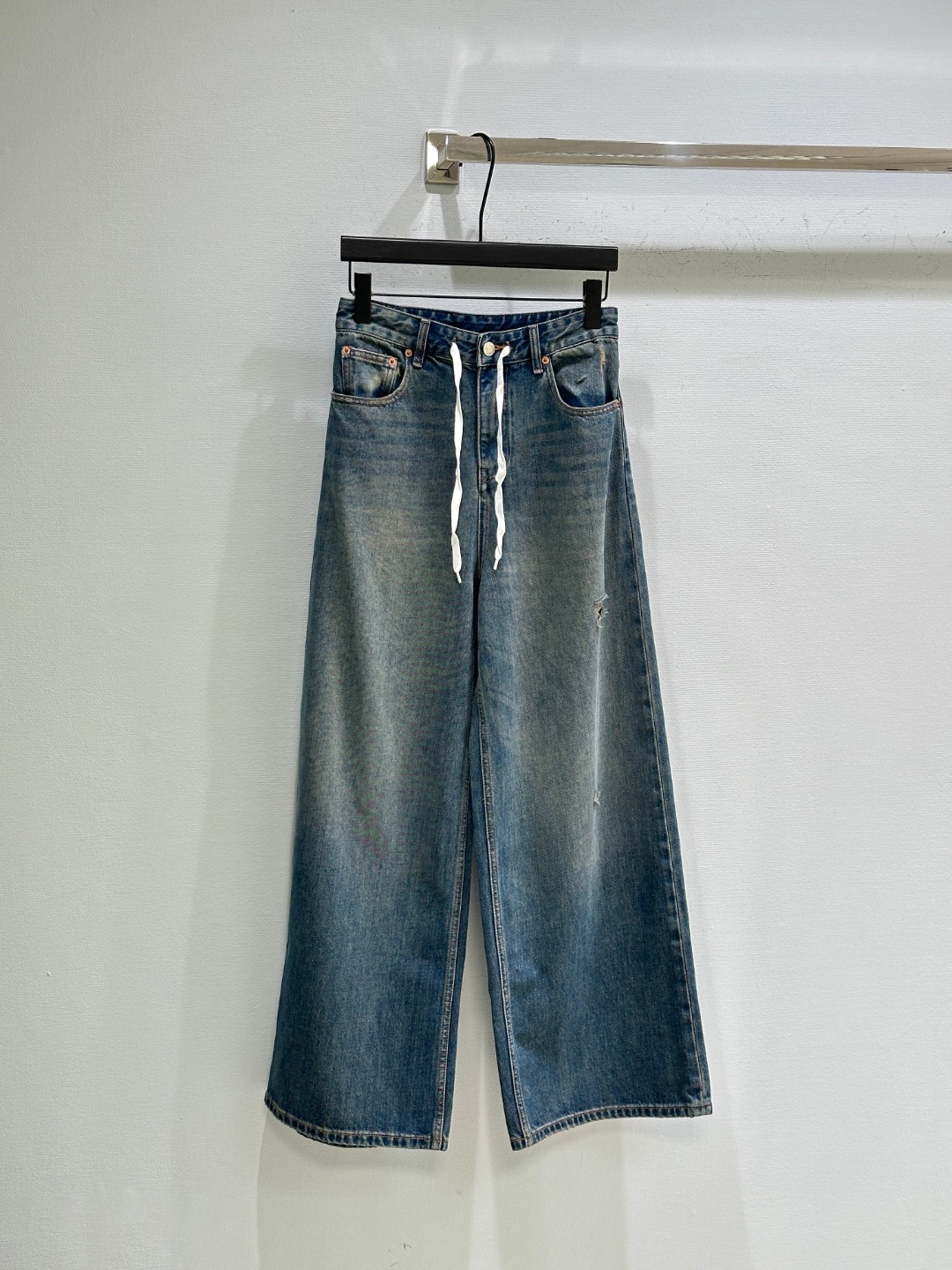 Title: MM6 SS20 Broad-Leg Jeans Description Summary: MM6 introduces rebellious broad-leg jeans with white ropes, vintage details, and unique branding for SS20 collection. - 图片 1