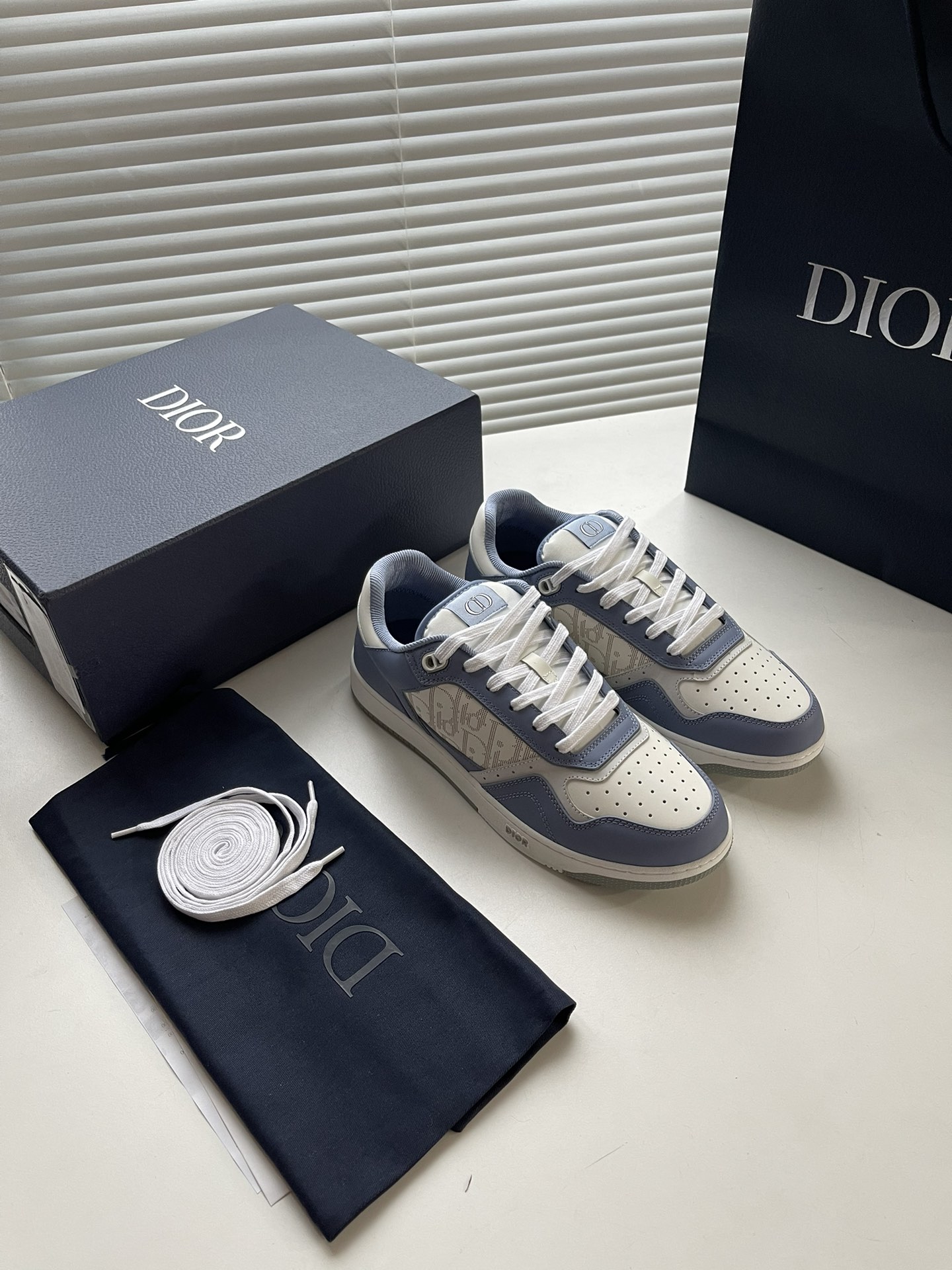 NO:639698,~ New 27 Low-top Sneakers This B27 low-top sneaker is Di~r's classic item. It is carefully made of Dior gray smooth cow leather and decorated with white Oblique Galaxy print-effect leather panels on the sides. The CD Icon-shaped lace eyelets are clever and delicate, and the two-color rubber sole, tongue and back side are all decorated with special details, making it more sophisticated. Fashionable and versatile, it can add color to various looks.  Size 35-40 (female) 39-45 (male) Color ice blue, silver grey, dior, sneakers, cowhide19860909～ 新款 27低帮运动鞋 这款 B27 低帮运动鞋是 Di～r的经典单品.采用迪奥灰光滑牛皮革精心制作,侧面饰以白色 Oblique Galaxy 印花效果皮革镶片.CD Icon 造型的鞋带孔眼巧妙精致,双色橡胶鞋底、鞋舌和后侧均饰以特色细节,更显精致.时尚百搭,可为各式造型增光添彩 码数35-40（女）39-45（男） 颜色冰蓝、银灰,,dior,sneakers,cowhide,Men's shoes