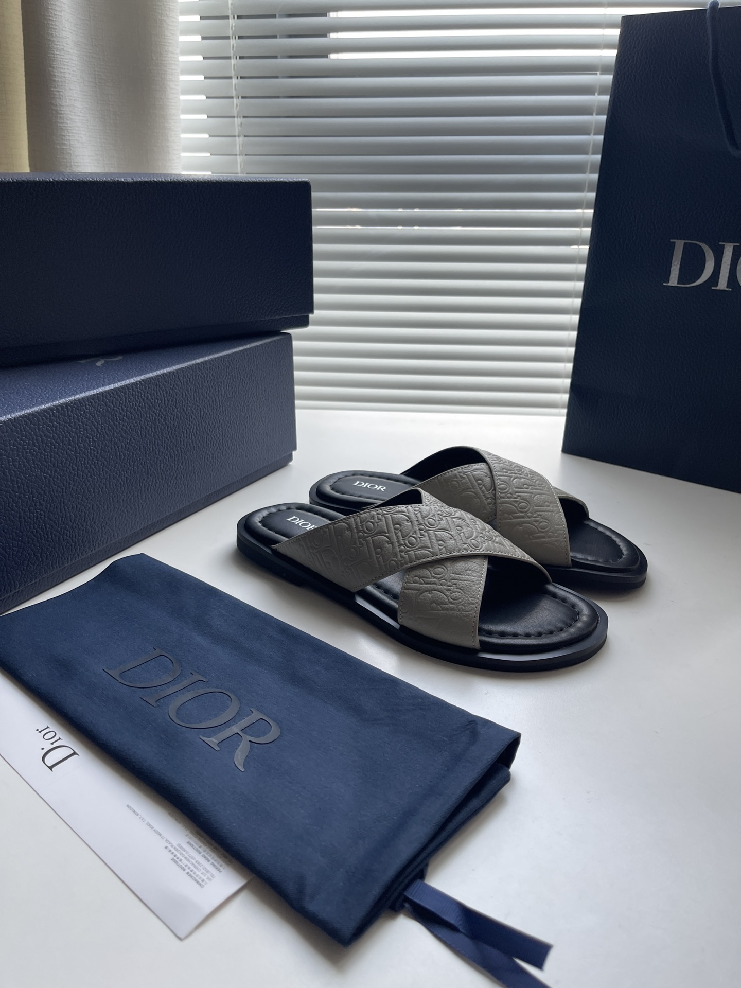 Sandales Dior Alias en cuir gris avec motif Dior Gravity pour un style élégant.