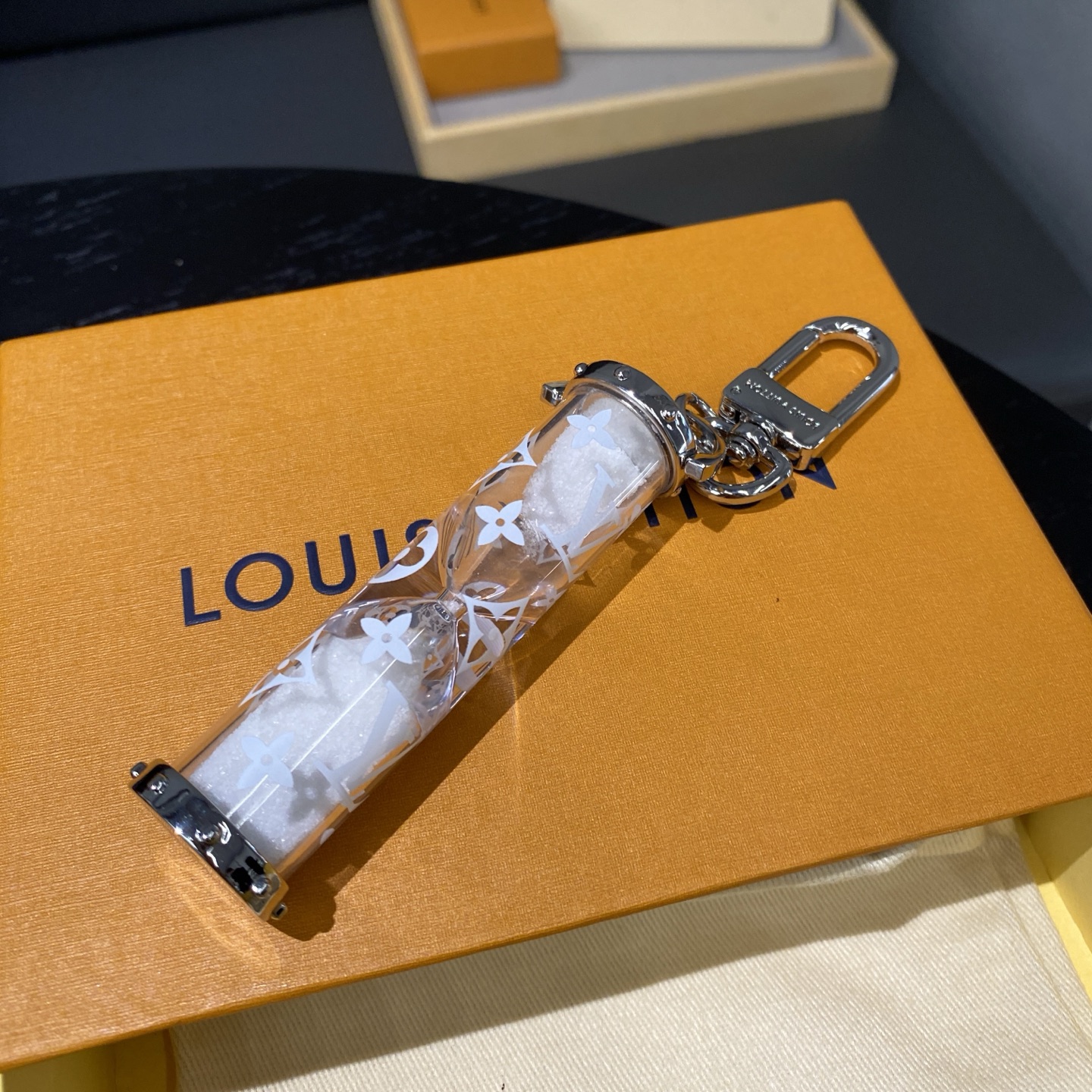 
 LV沙漏钥匙扣
M68830包饰与钥匙扣。
✨LV Chromatic包饰与钥匙扣续写系列设计，采用雾面线条勾勒抛光LV字母挂饰，搭配镂刻路易威登标识的弹簧和圈环，旨在吸引品牌拥趸的目光