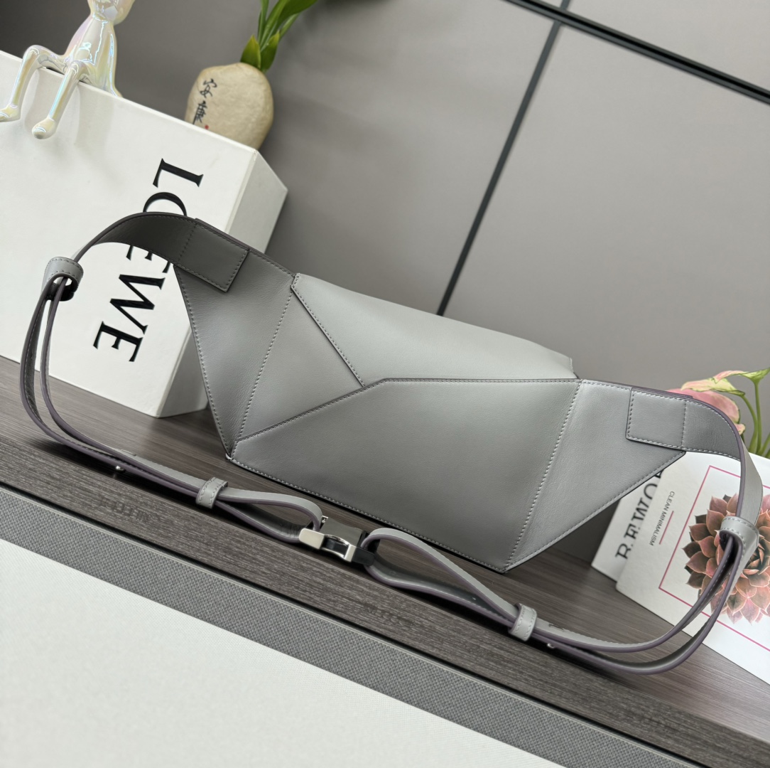 Loewe *长方体形状和精确的切割技术创造了 Puzzle 独特的几何线条这款小号腰包采用 牛皮革制成
