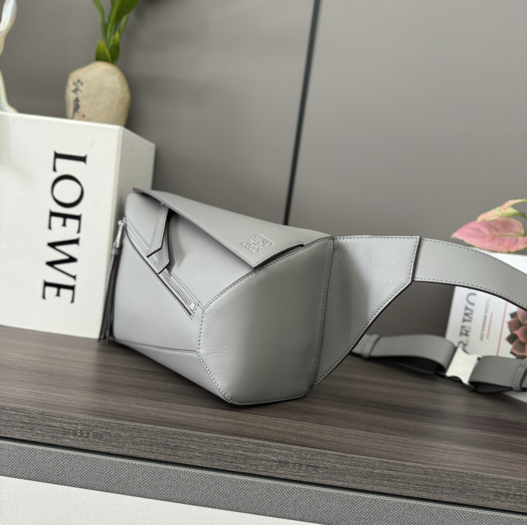 Loewe *长方体形状和精确的切割技术创造了 Puzzle 独特的几何线条这款小号腰包采用 牛皮革制成