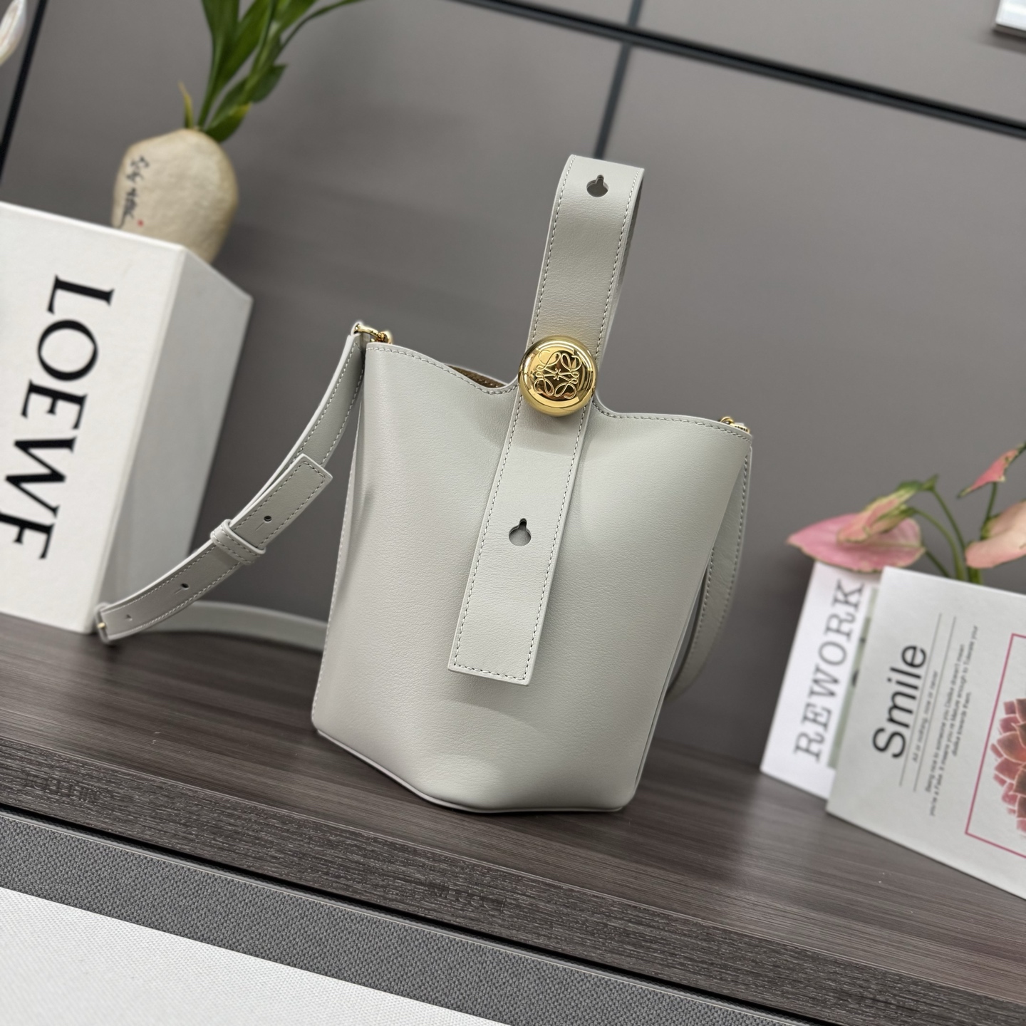 NO:343250,Lwmini柔软牛皮革Pebble Bucket水桶包 将纯粹的简约线条与瞩目设计风格巧妙融合,造就别具一格的创新的手袋设计.标记性的Anagram雕刻五金件兼具装饰和实用功能,可调节肩带长度并适合多种携带方式,独特的扭曲结构与微妙的细节相得益彰.此mini版本采用柔软牛皮革制成.可斜挎*肩背或手提*可调节可拆卸肩带*磁扣开合*内部口袋*合成革衬里*Anagram雕刻卵石. size:16*16*19.5CM 型号062342（配全套包装）,新款    Pebble Bucket水桶包,cowhideLwmini Soft Cowhide Pebble Bucket Bag Cleverly blends pure simple lines with eye-catching design style to create a unique and innovative handbag design. The marking Anagram engraving hardware combines decorative and practical functions, adjusts the strap length and is suitable for a variety of carrying methods, and the unique twisted structure complements the delicate details. This mini version is made of soft cowhide leather. Crossbody* shoulder or hand-held* adjustable removable shoulder strap* magnetic buckle closure* internal pocket* synthetic leather lining* Anagram engraving pebbles. size: 16*16*19.5CM Model 062342 (with full package), new model      Pebble Bucket Bag, c,Bag