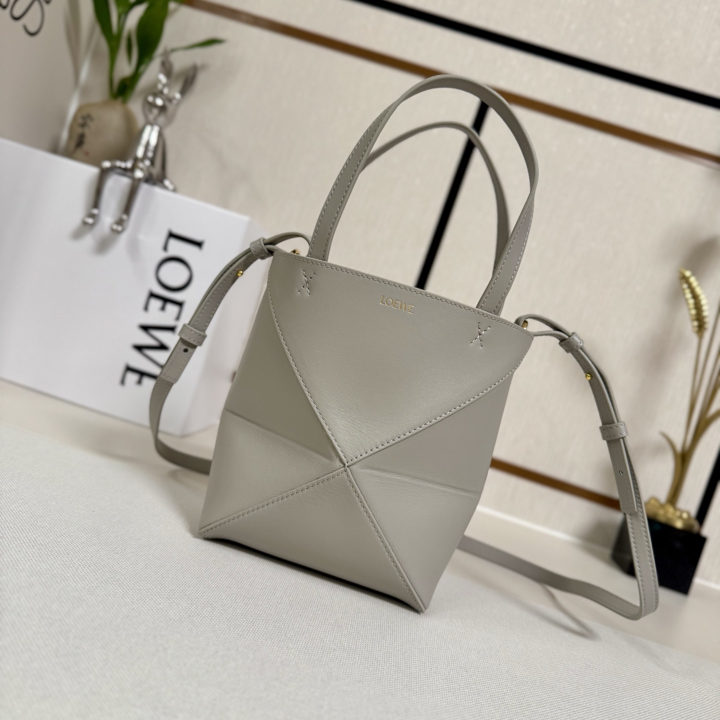 NO:342296,Lw's new mini glossy cowhide leather Puzzle Fold handbag draws inspiration from the geometric lines of the brand's classic handbag series and reinterprets it with geometric architectural aesthetics. It can be completely folded. It can be said that the travel companion brand uses creativity to create soft and light handbags with low-key and elegant LOEWE brand logo. This mini version is made of glossy cowhide, shoulder-back, cross-back or hand-held, removable and adjustable shoulder straps, suede lining Lw gold-plated. size: 16.5*9.5*20CM Model 052322 (with full package), folding bag Puzzle Fold Tote, loewe, cowhide19860909Lw新款迷你亮面牛皮革Puzzle Fold 手袋从品牌经典手袋系列的几何线条汲取灵感以富含几何建筑美感的镶片重新诠释,能完全折叠,可谓旅行良伴品牌运用创意巧思打造柔软轻盈的手袋,搭配低调雅致的 LOEWE 品牌标志.此迷你版本采用亮面牛皮革打造、可肩背、斜背或手提 可拆卸可调整肩带 绒面革衬里Lw烫金. size:16.5*9.5*20CM 型号052322（配全套包装）,折叠包Puzzle Fold Tote,loewe,cowhide,Bag